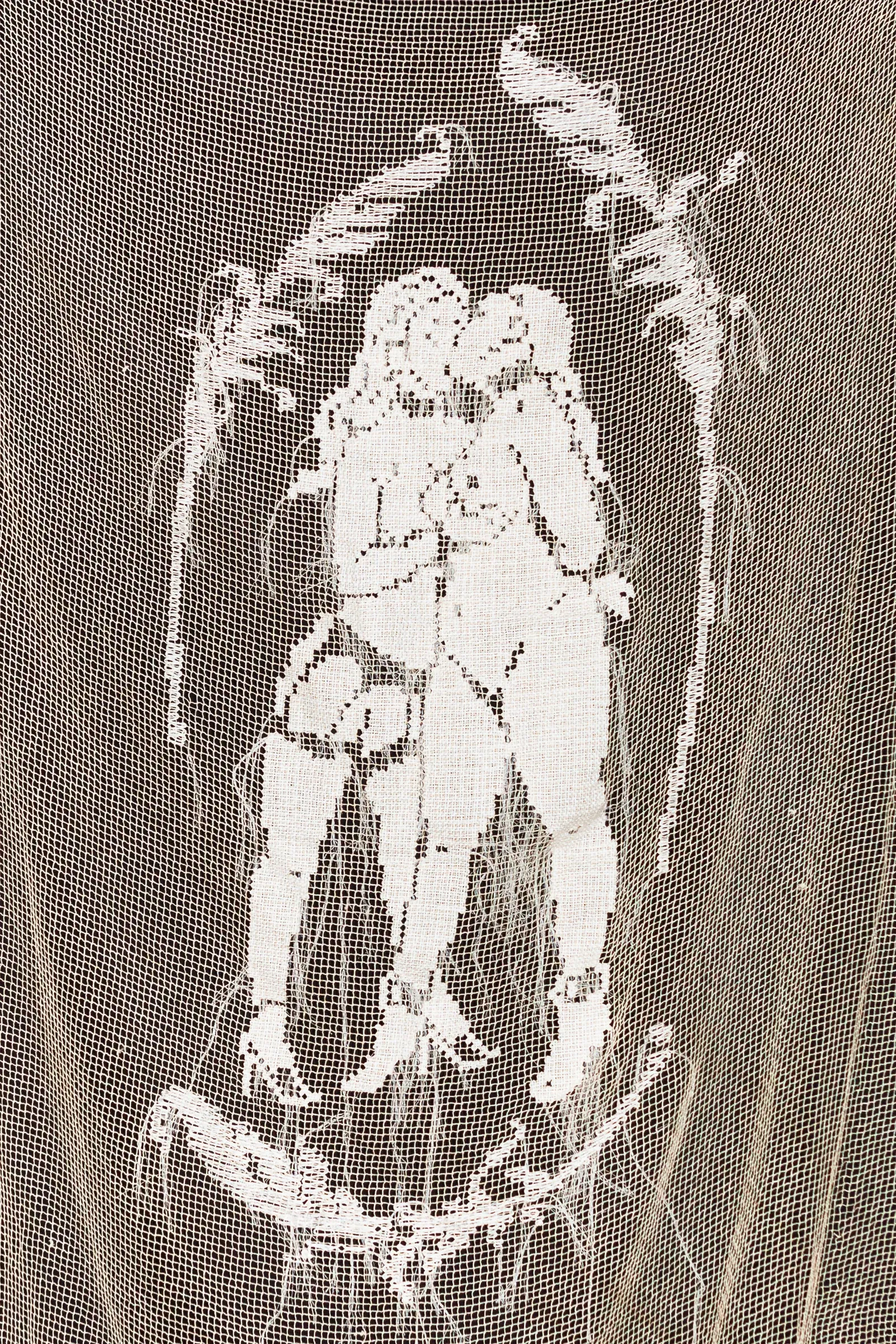 Exhibition review of Jingyi Li: A Charm of Powerful Trouble at ACUD Galerie, Berlin, 2026. Close view of two embracing figures worked in white filet lace against an open net ground.