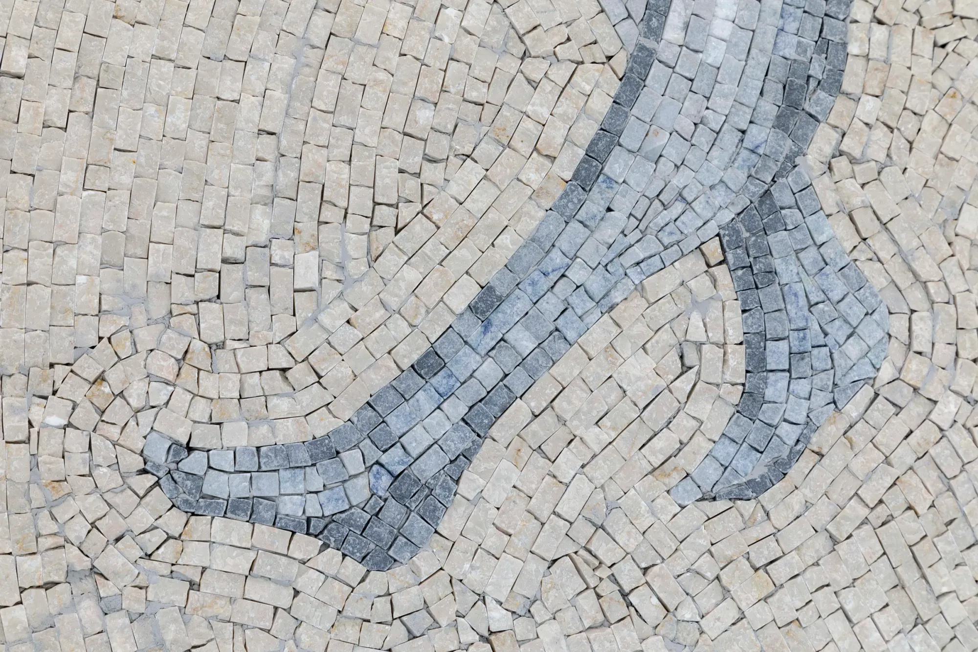 Exhibition review of Riikka Anttonen: Vertere at Sinne, Helsinki, 2026. Macro detail of marble mosaic tesserae in beige and grey forming a curved figure outline.