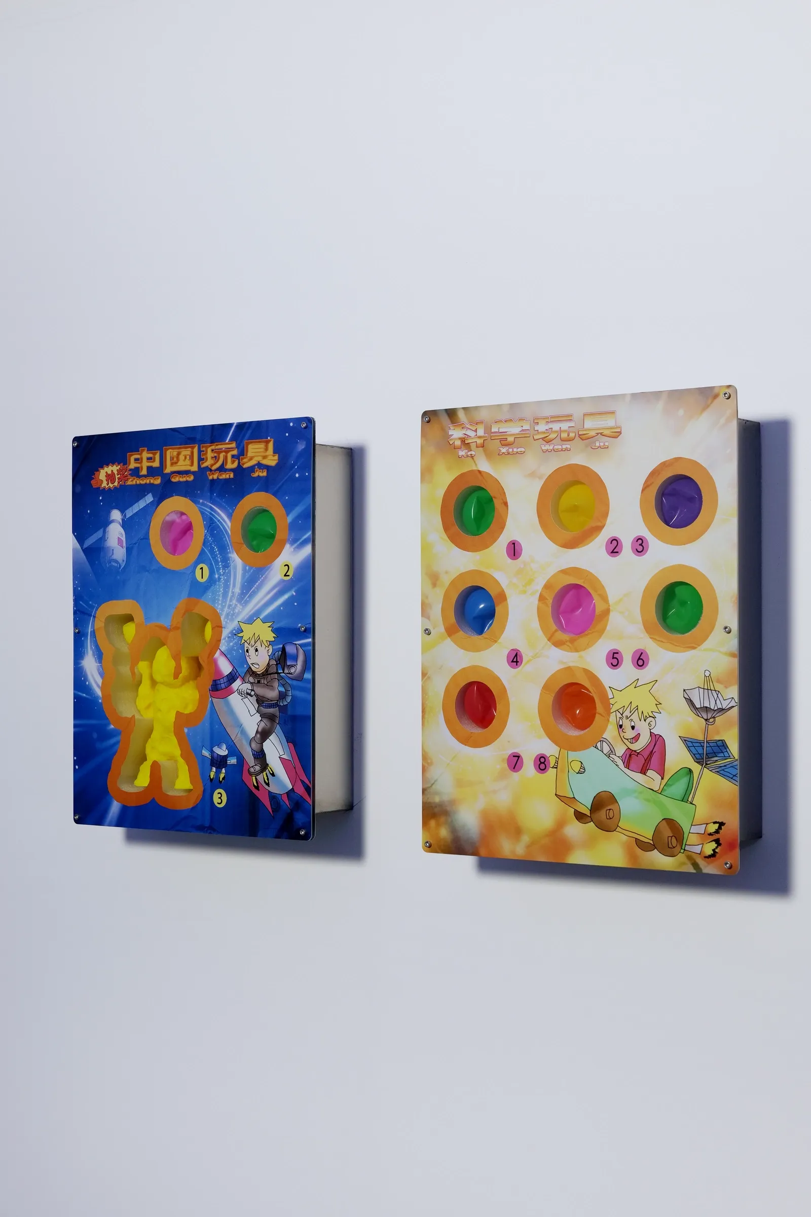 Exhibition review of Zhang Ting: TechDiumMory at TANK Shanghai, Shanghai, 2026. Two printed acrylic toy boards with colored ball hollows mounted side by side on a wall.