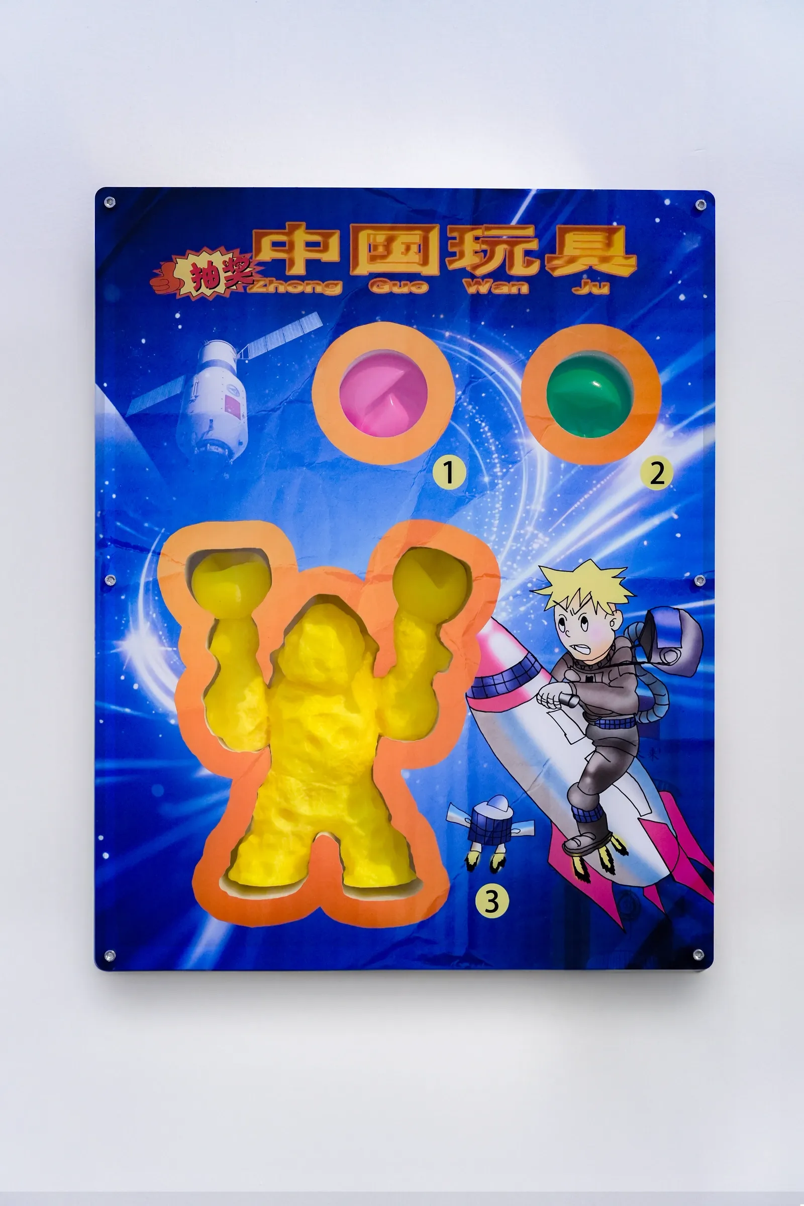 Exhibition review of Zhang Ting: TechDiumMory at TANK Shanghai, Shanghai, 2026. Blue printed board with a yellow foam figure hollow, two ball hollows and a boy on a rocket.
