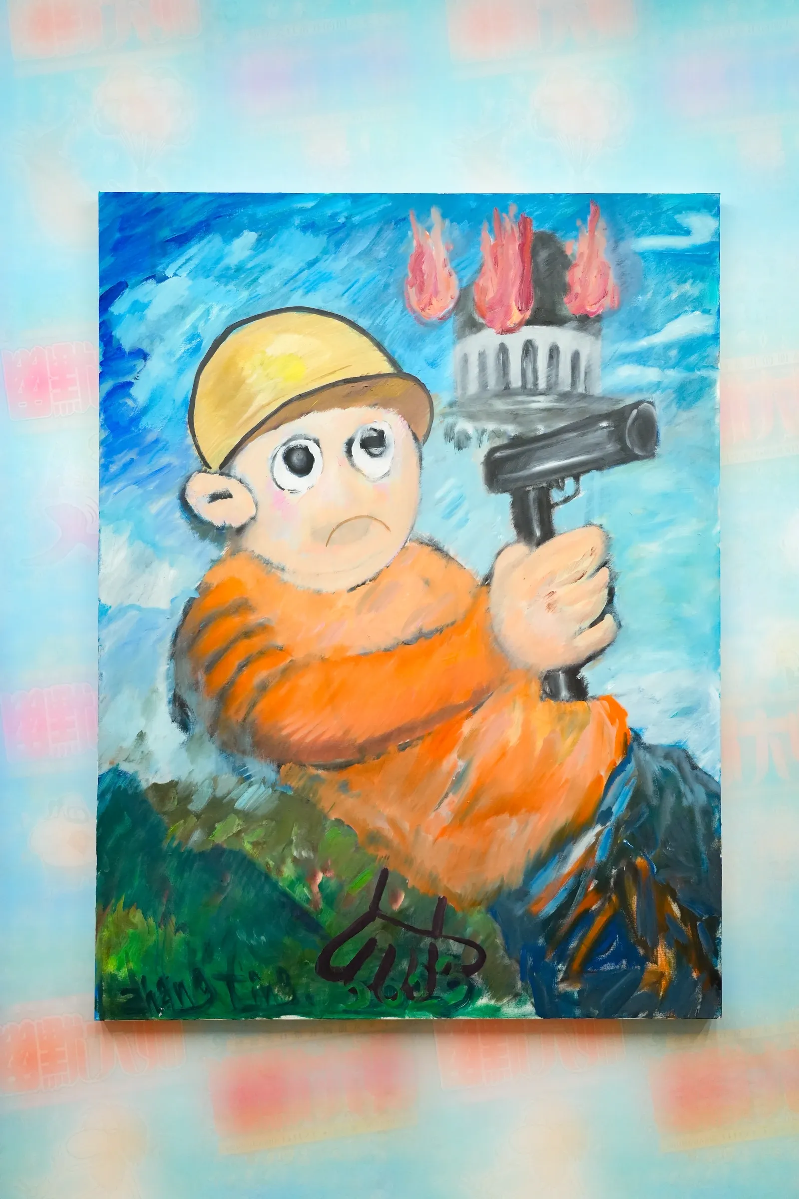 Exhibition review of Zhang Ting: TechDiumMory at TANK Shanghai, Shanghai, 2026. Boy in orange with a yellow helmet holding a black pistol below a burning tower.