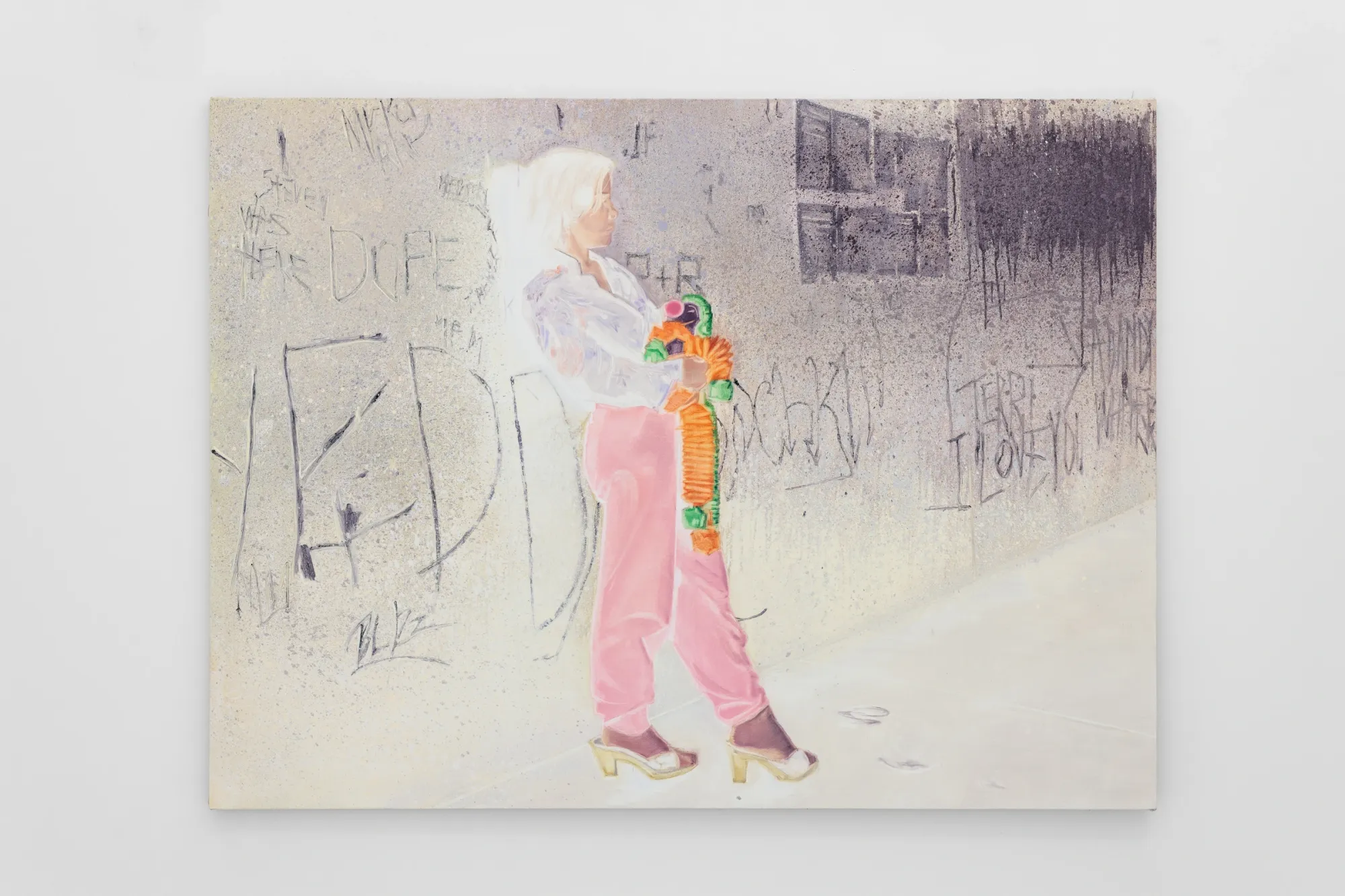 Exhibition review of Zofia Pałucha: Mother of One at HOS Gallery, Warsaw, 2026. Girl in pink trousers holding a bright toy against a grey graffiti wall.