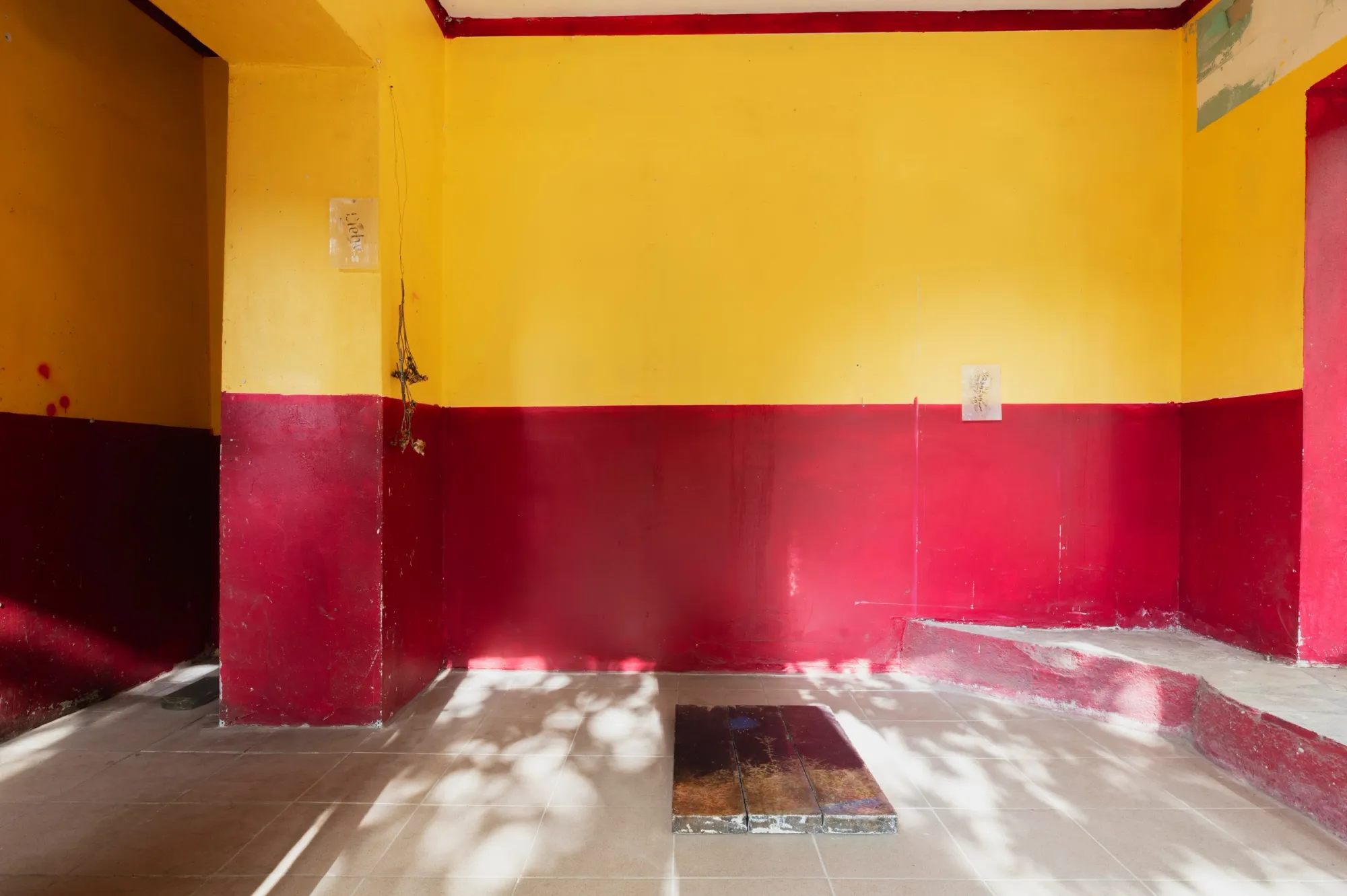 Aubrey&nbsp;Theobald&nbsp;and&nbsp;Kristina&nbsp;Popov,&nbsp;Phantom&nbsp;Pförtnerhaus&nbsp;Chapter&nbsp;3,&nbsp;Berlin,&nbsp;2026.&nbsp;Yellow&nbsp;and&nbsp;crimson&nbsp;room&nbsp;with&nbsp;a&nbsp;dark&nbsp;artwork&nbsp;lying&nbsp;on&nbsp;the&nbsp;tiled&nbsp;floor.