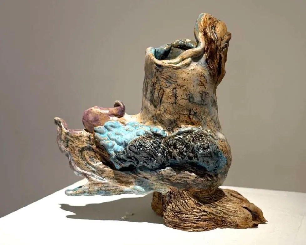  ALT: Christina Arark: ceramic sculpture of a branching organic form with blue glazed areas on a white plinth.