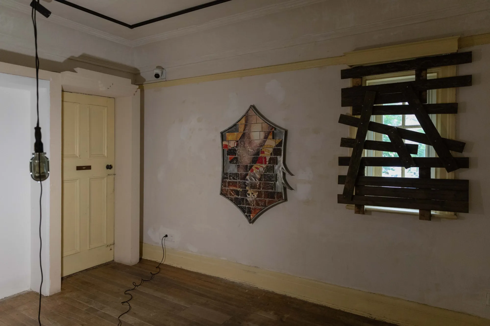 Fangyang, E.SCAPE art space, Shanghai: hexagonal brick-tile work on a plaster wall next to a window boarded with planks.