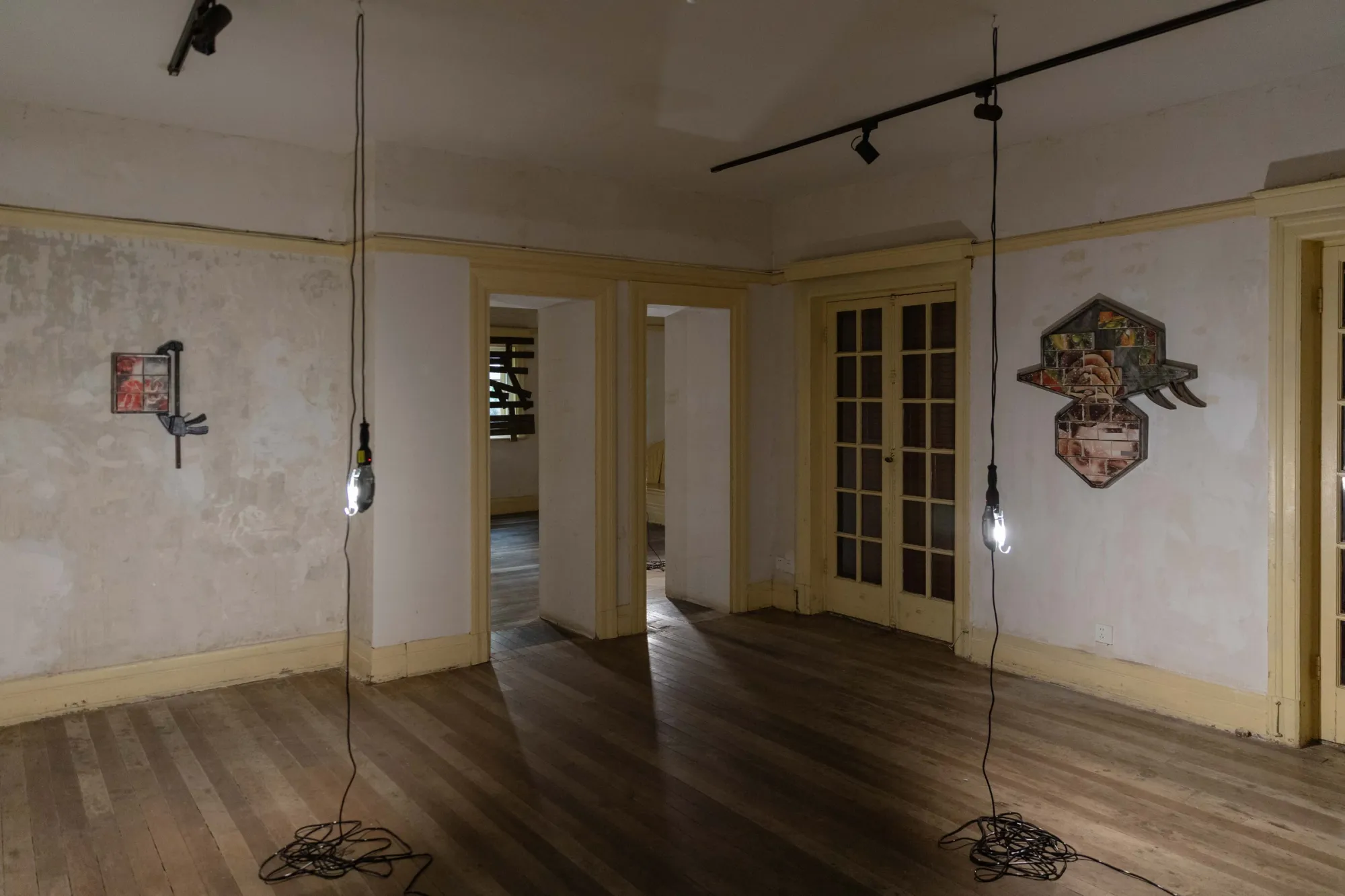 Fangyang, E.SCAPE art space, Shanghai: small clamp-mounted work and a hat-shaped wall work seen through open doorways above a wooden floor.