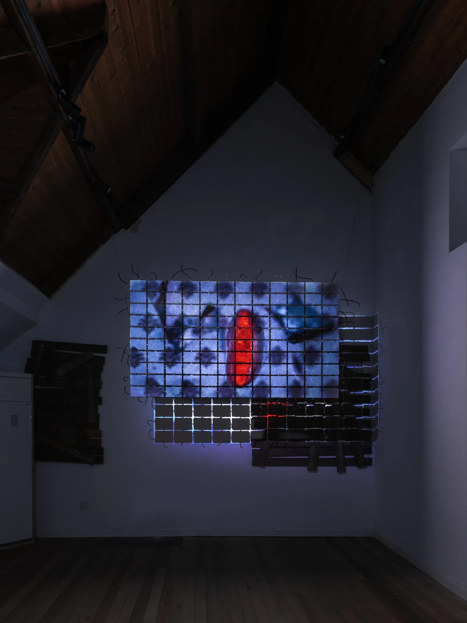 Fangyang, E.SCAPE art space, Shanghai: video projected onto a grid of clay blocks, showing a red oval shape on a blue patterned surface.