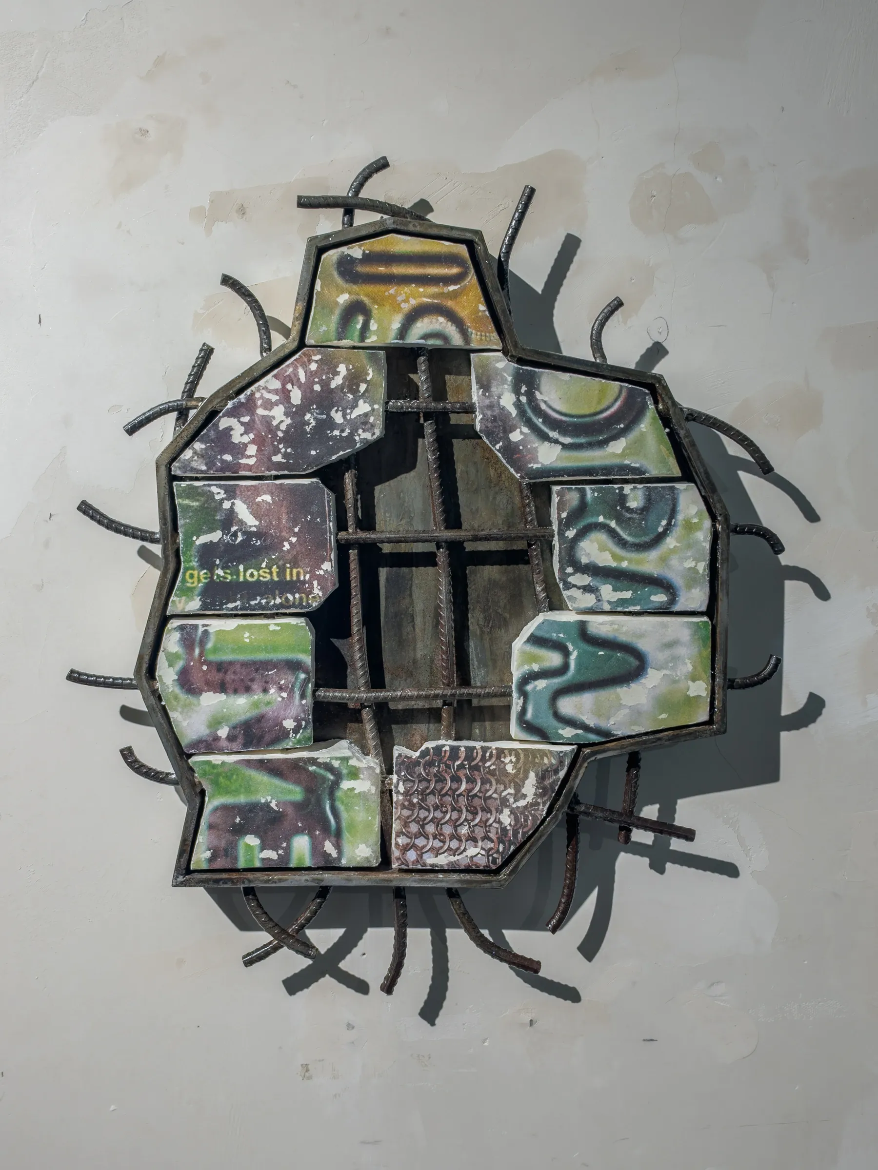 Fangyang, E.SCAPE art space, Shanghai: green and grey printed clay tiles in a steel frame with curved rebar spikes on a white wall.