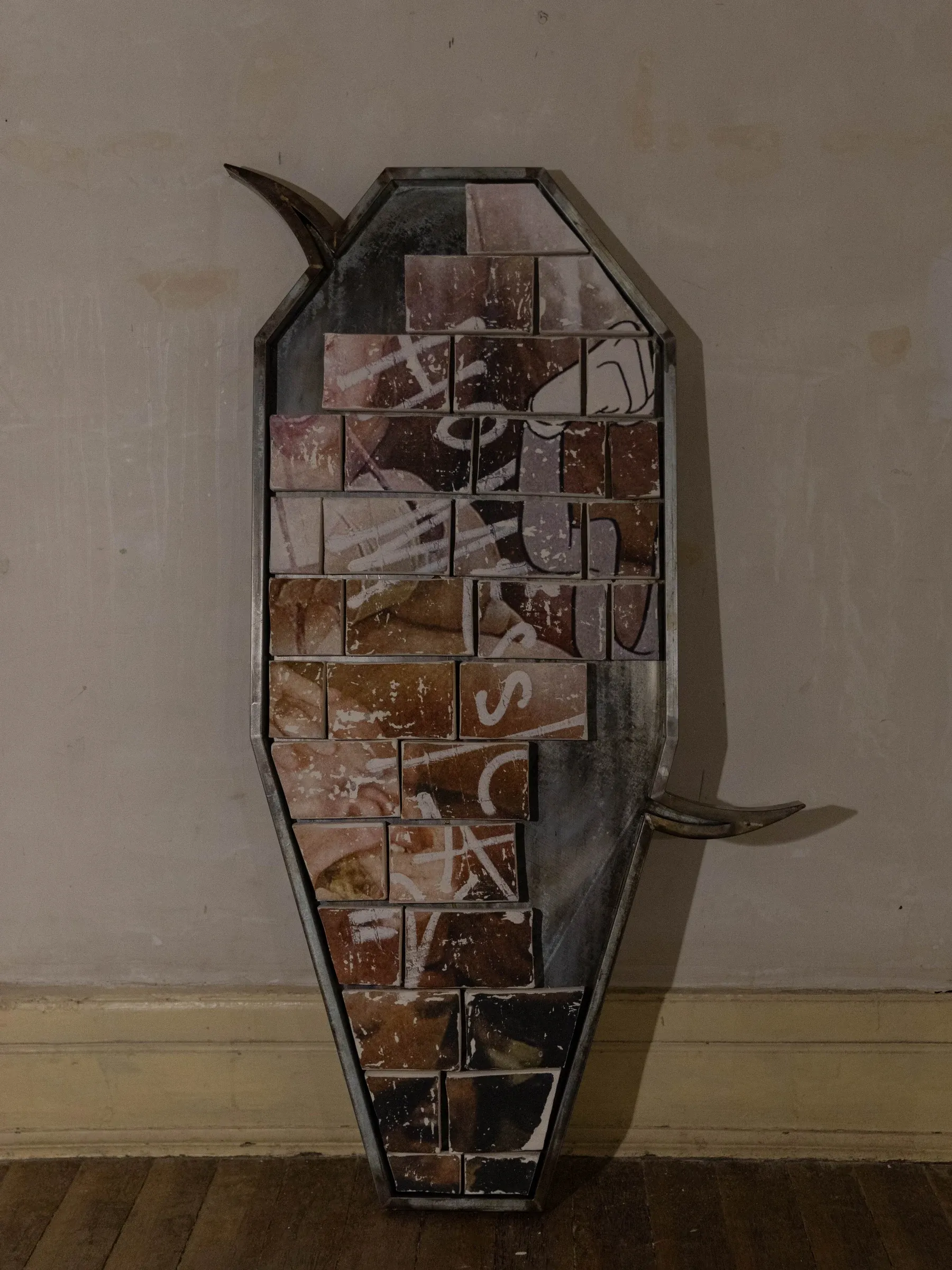 Fangyang, E.SCAPE art space, Shanghai: upright coffin-shaped steel frame with brown clay tiles and white painted marks, standing against a wall.