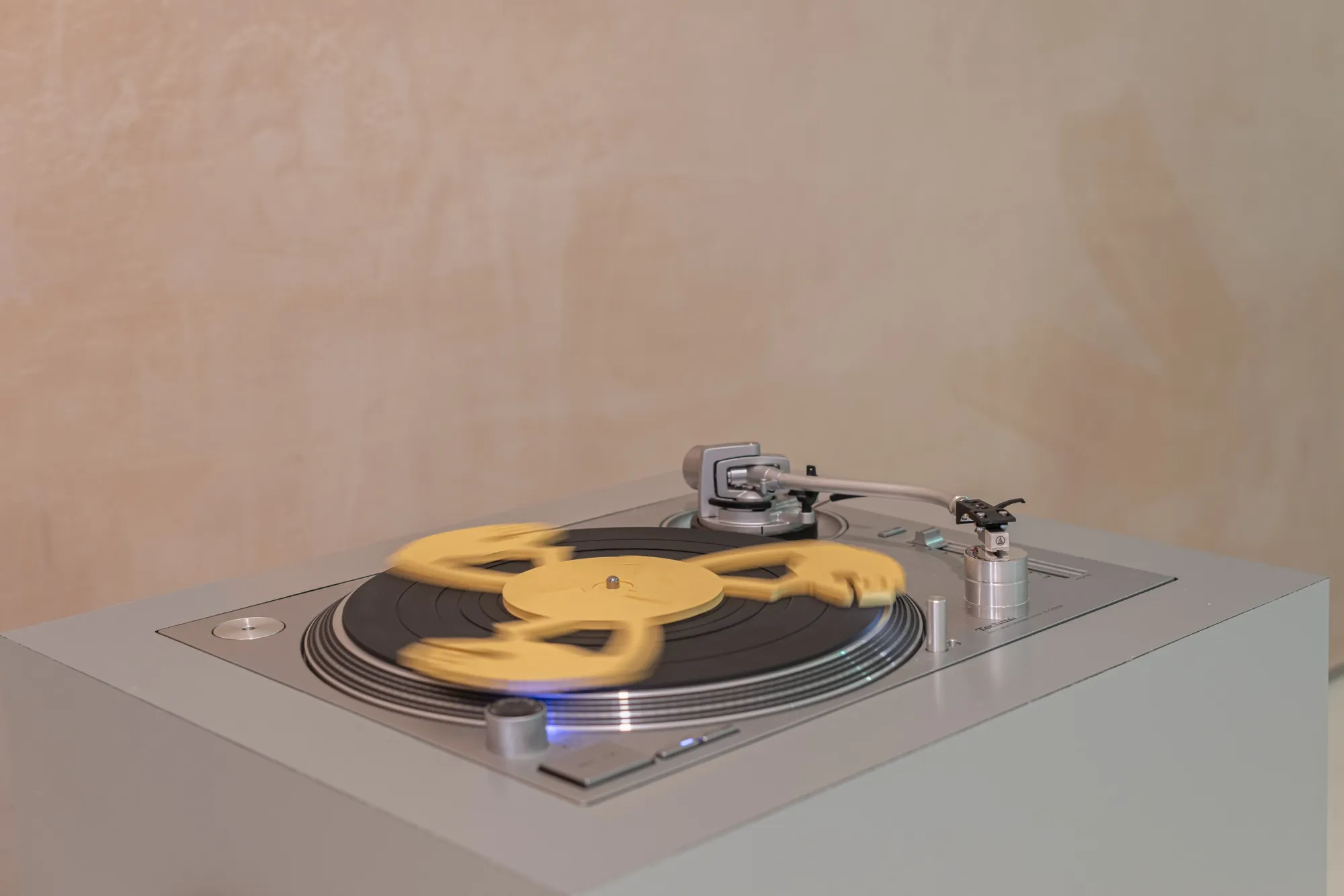 Detail of Finbar Prior's The Eternal Frogs at OUTPOST Gallery, Norwich, 2026, showing a yellow disc blurred in motion on a turntable.