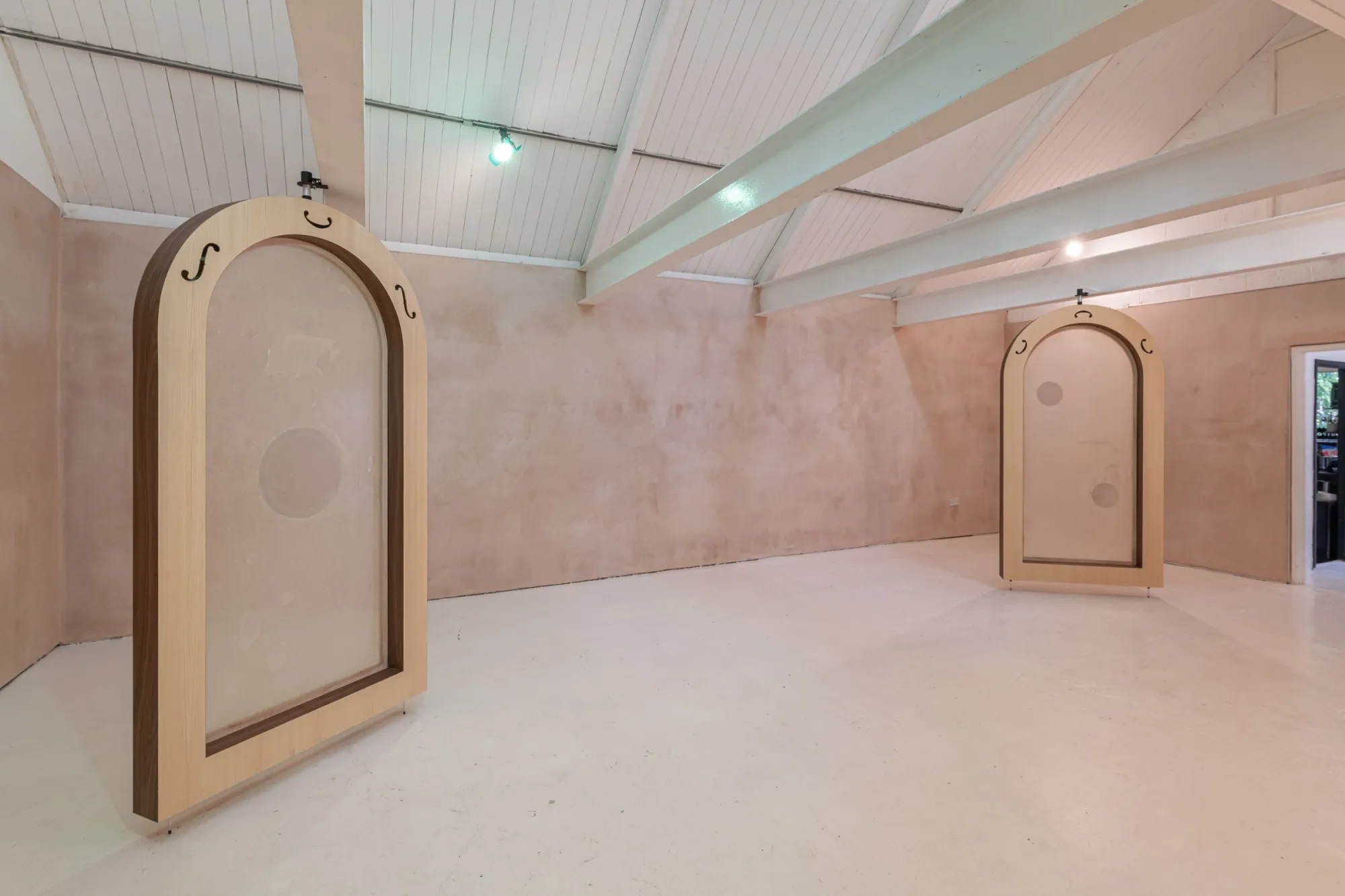 Installation view of Finbar Prior's Tympanums at OUTPOST Gallery, Norwich, 2026, showing two arched wooden frames with translucent membranes.