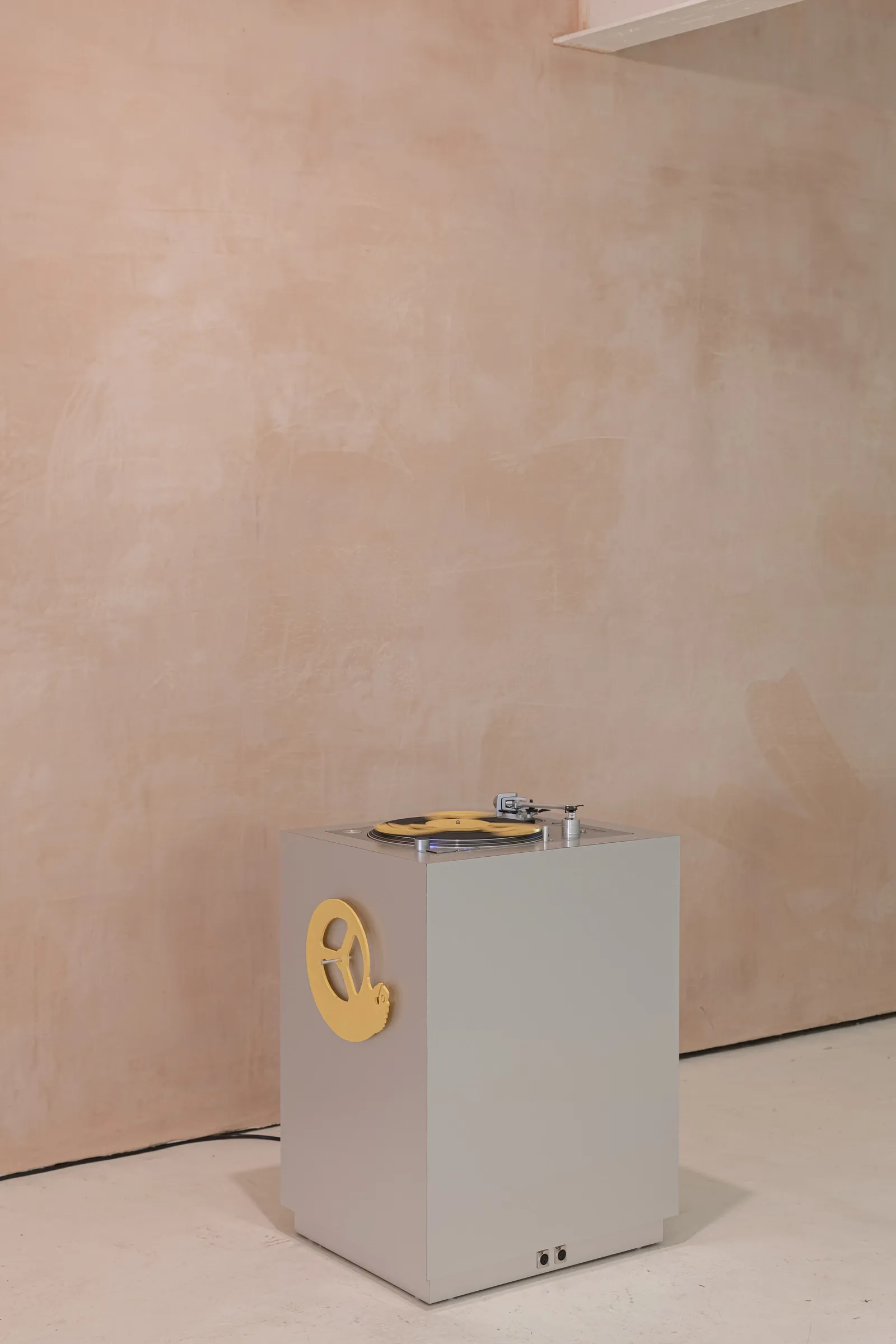 Finbar Prior's The Eternal Frogs at OUTPOST Gallery, Norwich, 2026, showing a turntable on a grey plinth with a yellow sculptural disc.