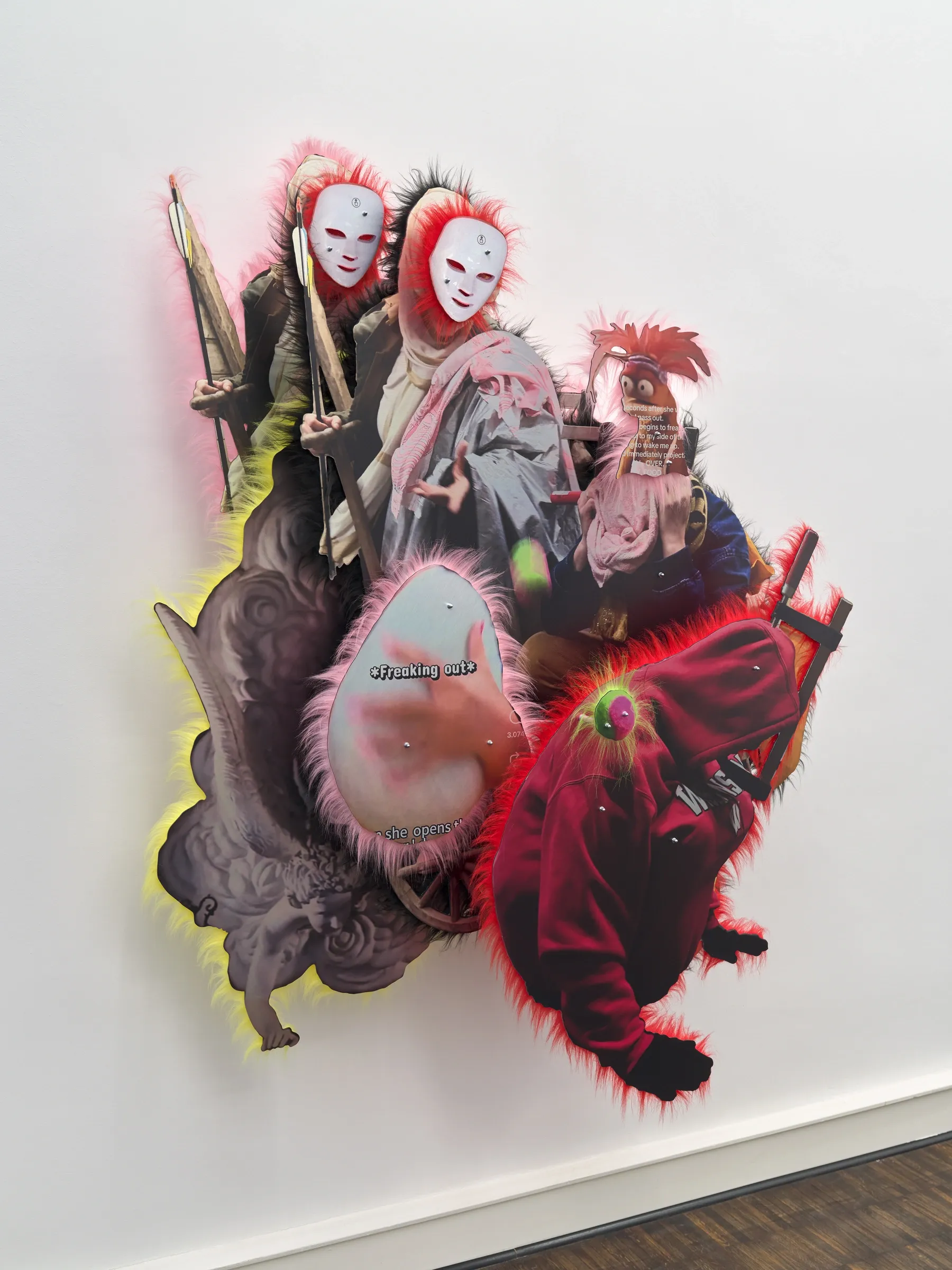 Iris Helena Hamers, PAW, Düsseldorf: Angled view of a wall work with two white-masked figures, a red hooded garment, a winged cherub and pink and red fur edging.