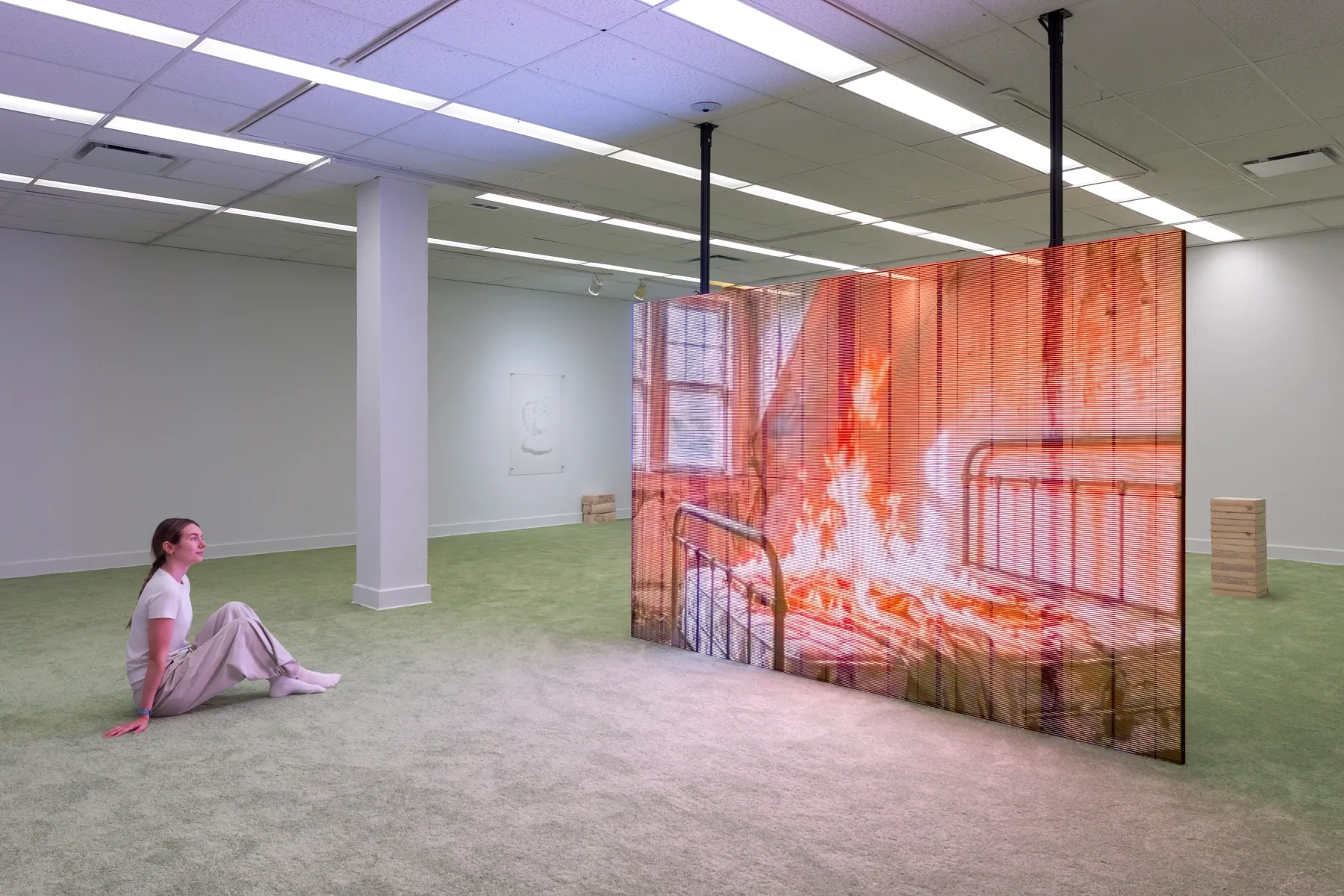 Patrick Bérubé at Plein Sud, Longueuil. Visitor watching an LED image of a burning iron bed.