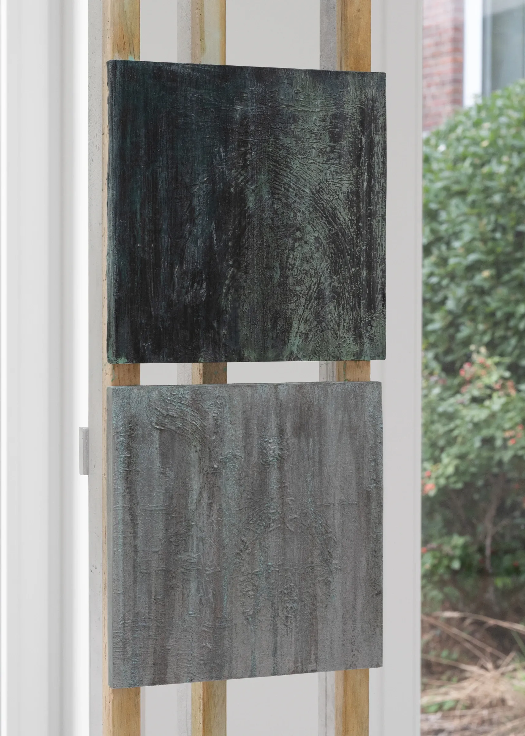 Exhibition review of Simon Bultynck: A. Aubry, A. Colin, P. Lippens, A. Oosterlinck, C. Wynants at CONVENT Space for Contemporary Art, Ghent, 2026. Close-up of two textured bronze panels, one dark green-black and one grey-green, mounted on wooden easel uprights.