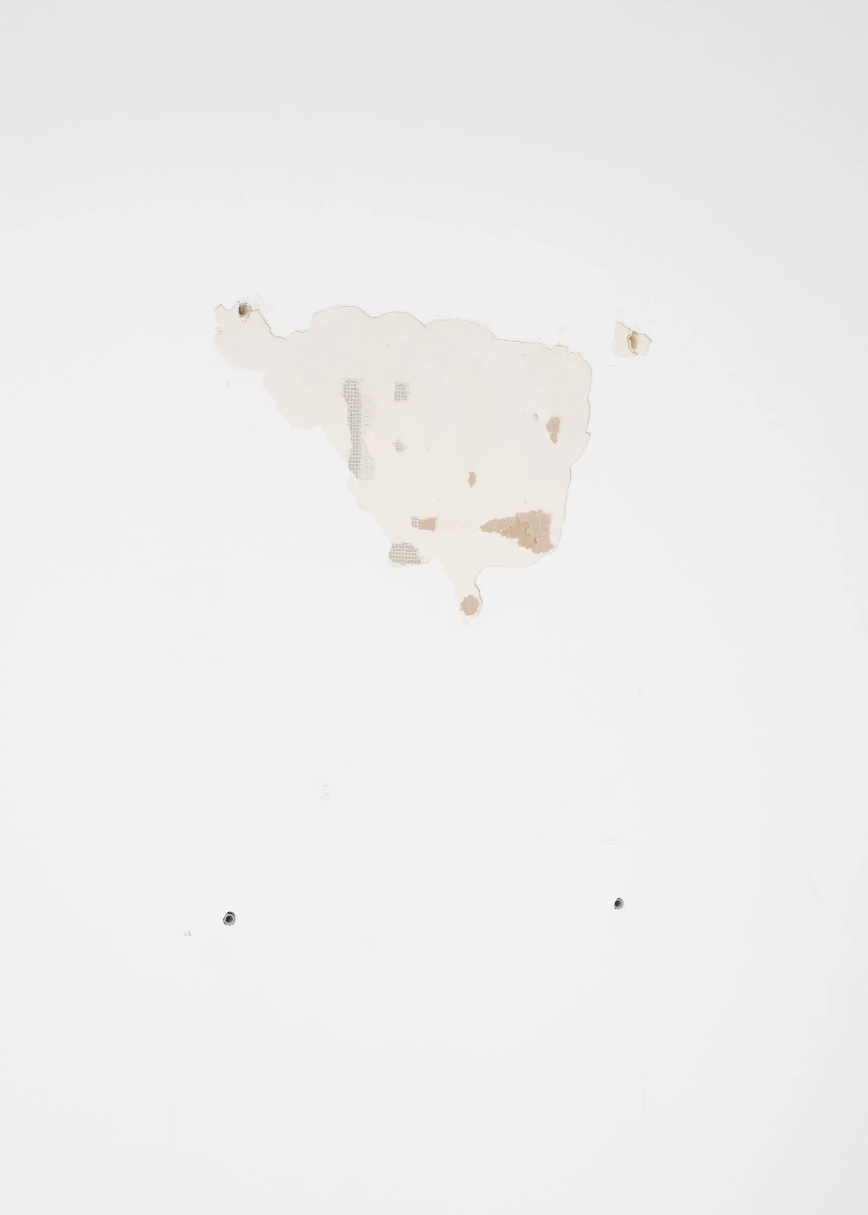 A. Oosterlinck, C. Wynants at CONVENT Space for Contemporary Art, Ghent, 2026. Patch of exposed wall plaster with small holes on a white gallery wall.