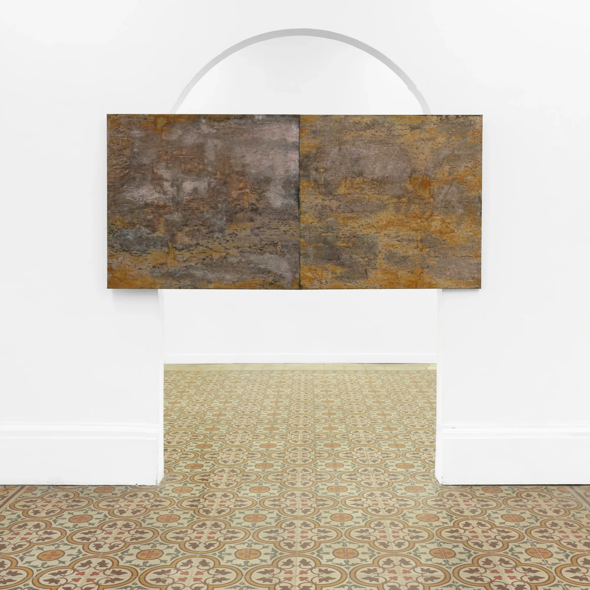 Taylah Hasaballah, INDICATRIX at The Address, Brescia, 2026. Two joined rust and ochre panels in a white arched opening.