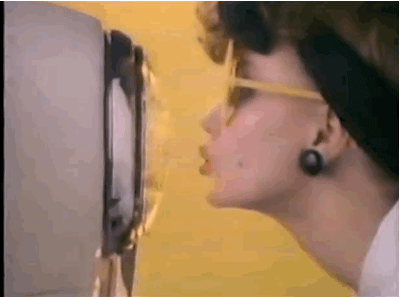 Woman in ’80s style sunglasses leans in to kiss a retro television, symbolizing pop-culture nostalgia that fashion embraces and art avoids.