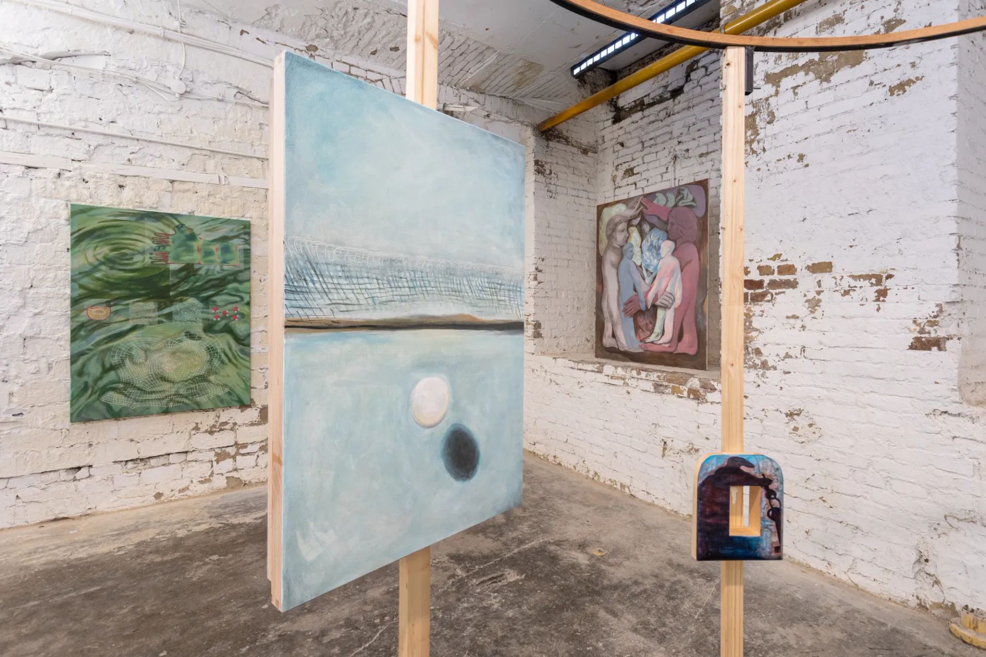 Gallery Rechnitzer, Budapest, 2026, showing installation with suspended wooden structure and paintings by Júlia Csapó, Eszter Kálóczy, and Emma Kling