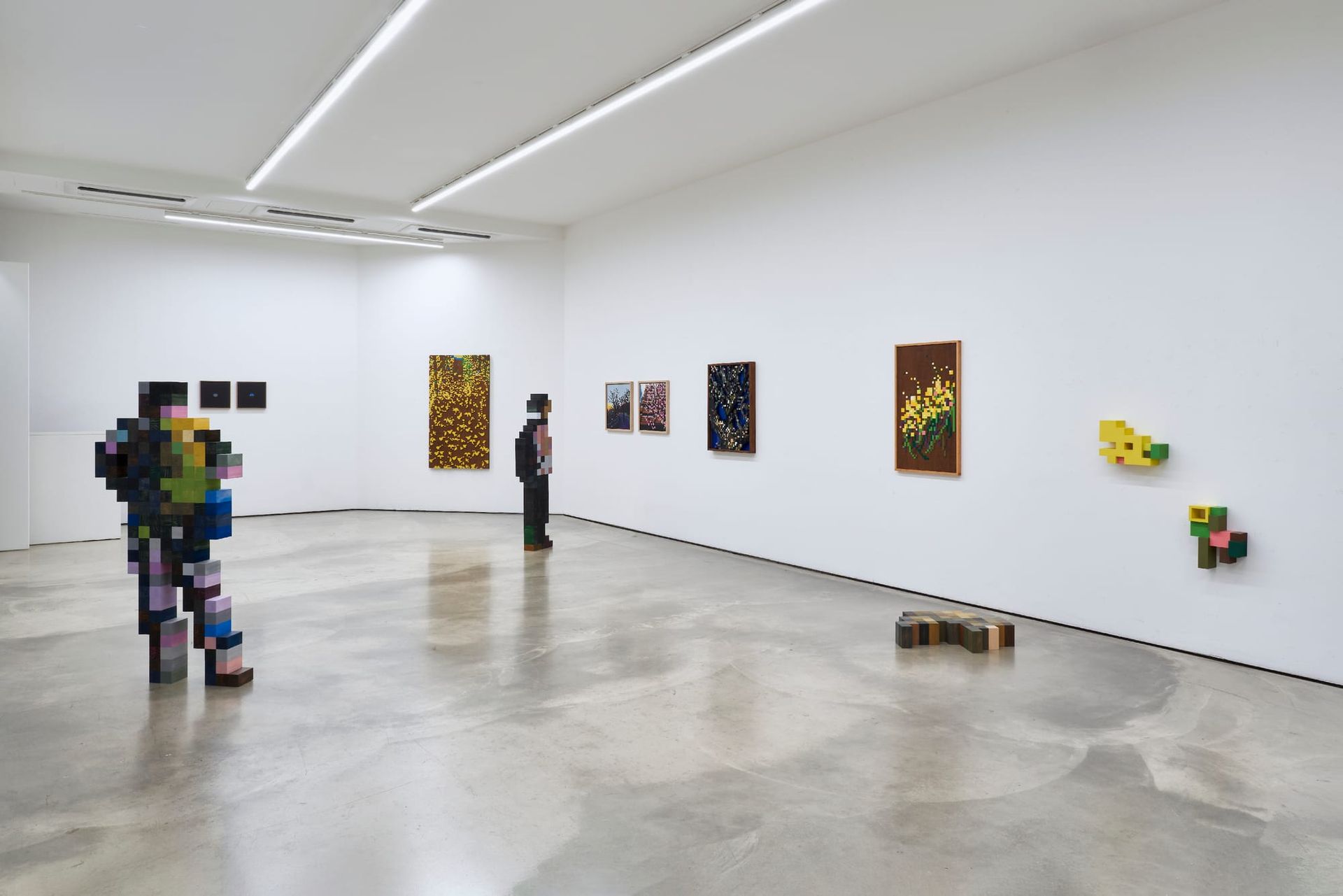 Catapult Contemporary Artist Profile Feature: Jaebum Joo, studio practice and artwork at Hakgojae Gallery, Seoul, 2026. Gallery view with two wood-block figures and wall-mounted pixel panels.