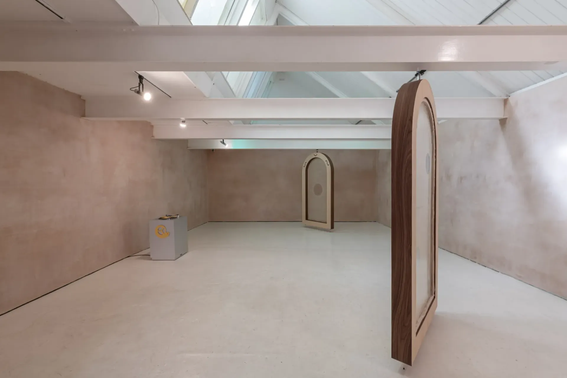 Installation view of Finbar Prior's Tympanums at OUTPOST Gallery, Norwich, 2026, showing arched wooden frames in a pink-walled exhibition space.