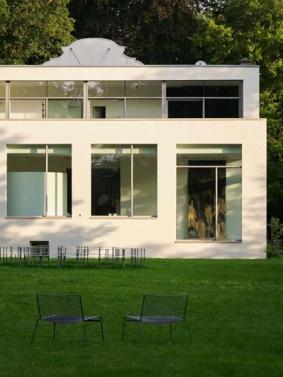 Modernist white Wehrmühle building surrounded by trees, venue of the 2025 group exhibition Some Degree of Friction.