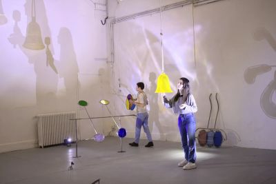 Romane Charlot, ÇA TOURNE, 2024. Installation view with luminous yellow blown glass sculpture and colored glass elements projecting light and shadows. Catapult - Artist in focus series