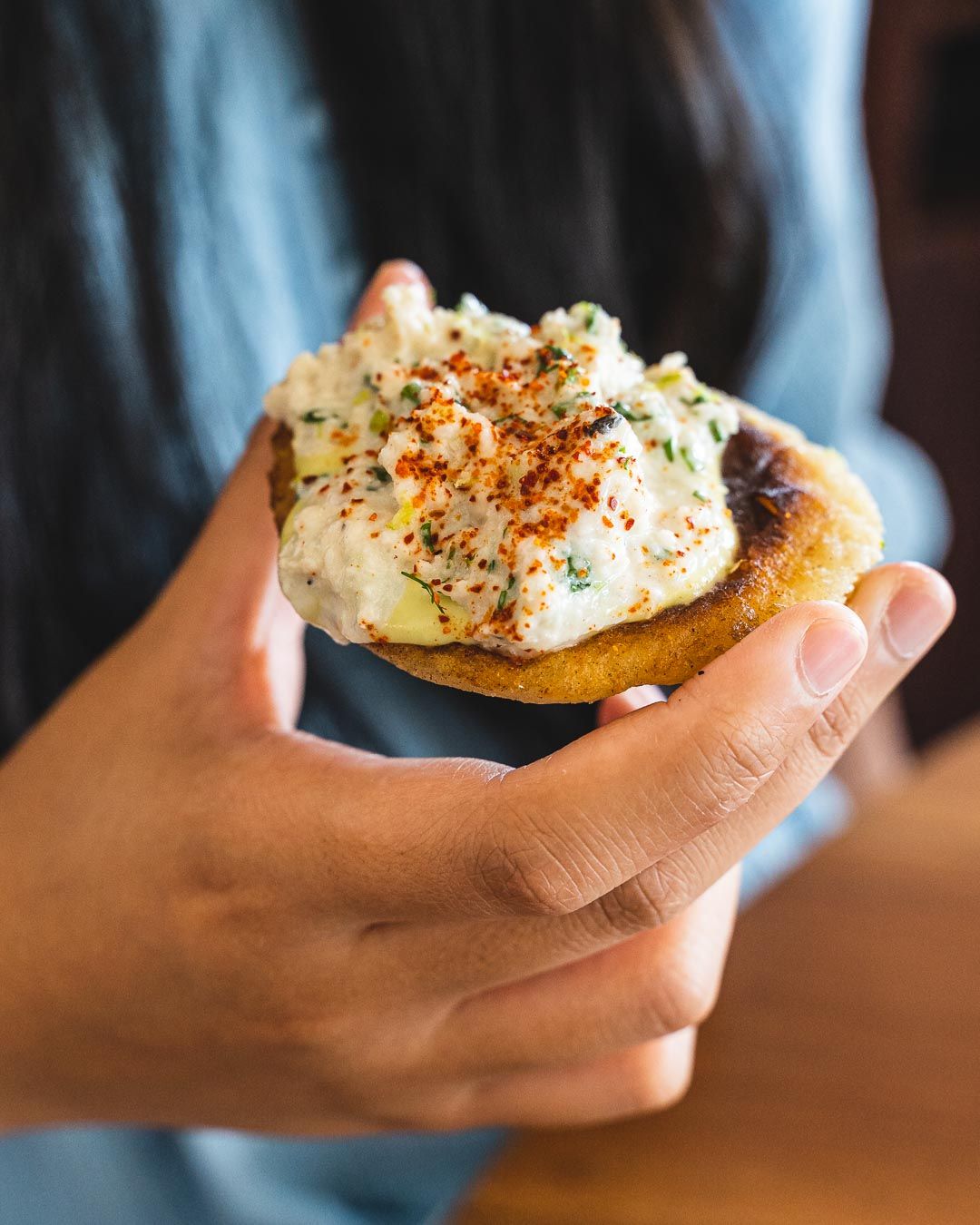 Hand holding an arepa with crab meat