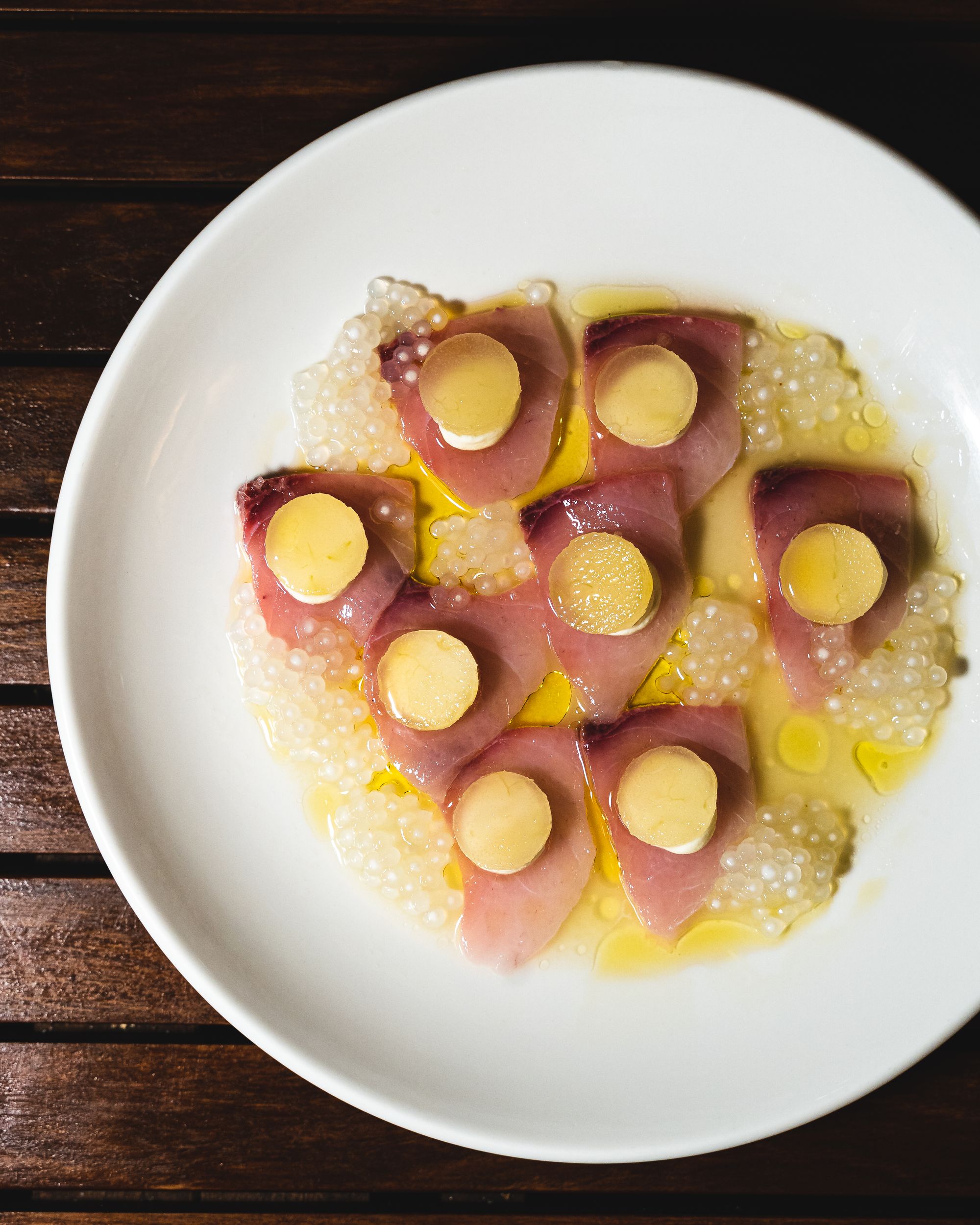 Kingfish sashimi slices served with a small circular slice of pear on-top with tapioca pearls on the side