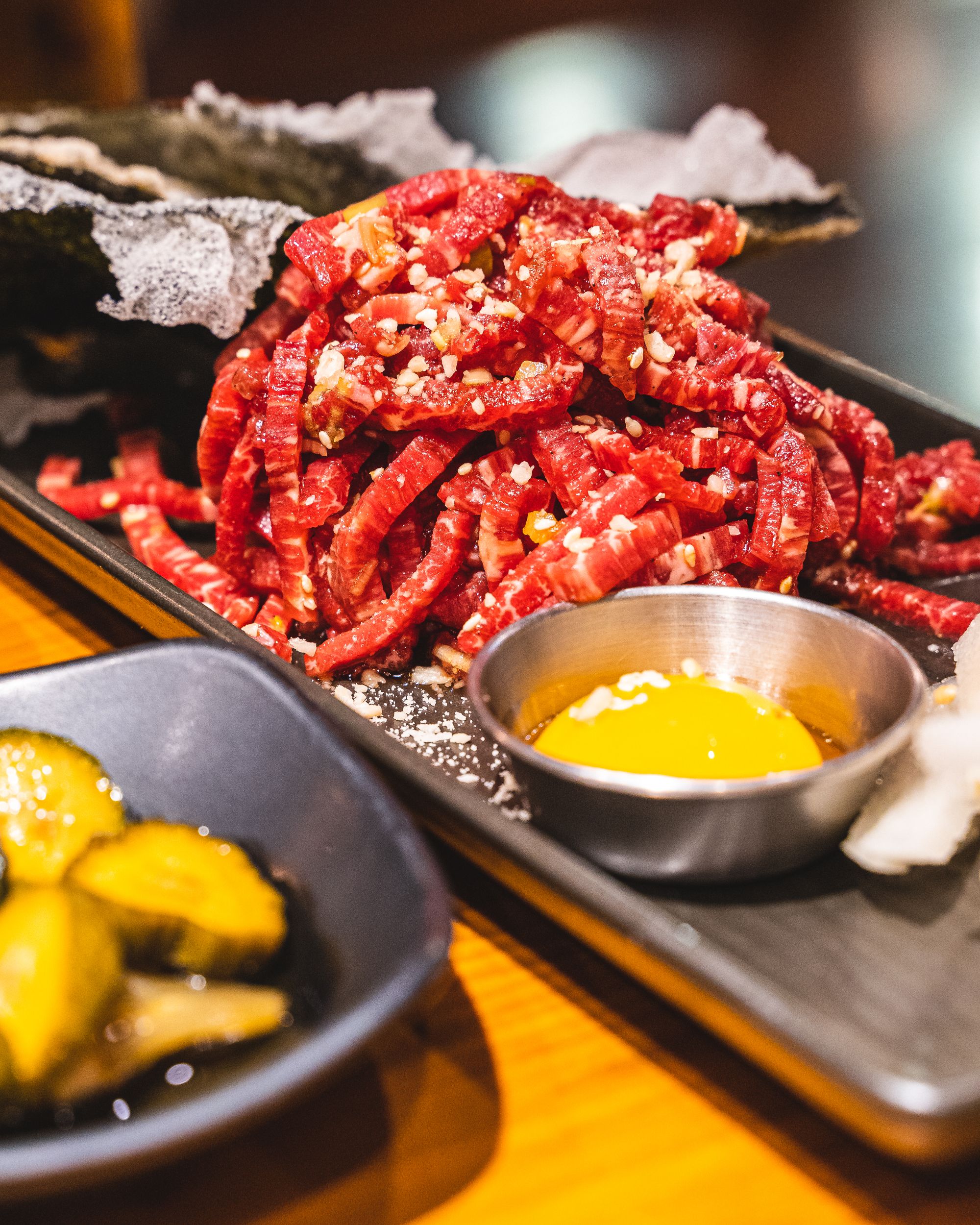 Korean beef tartare cut into strands with an egg yolk on th eside