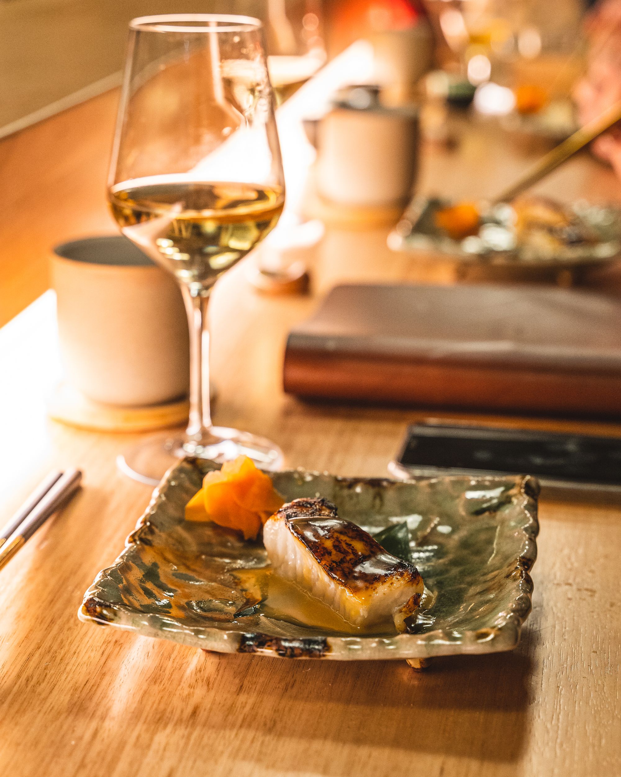 Close up of toothfish with miso sauce on a square plate