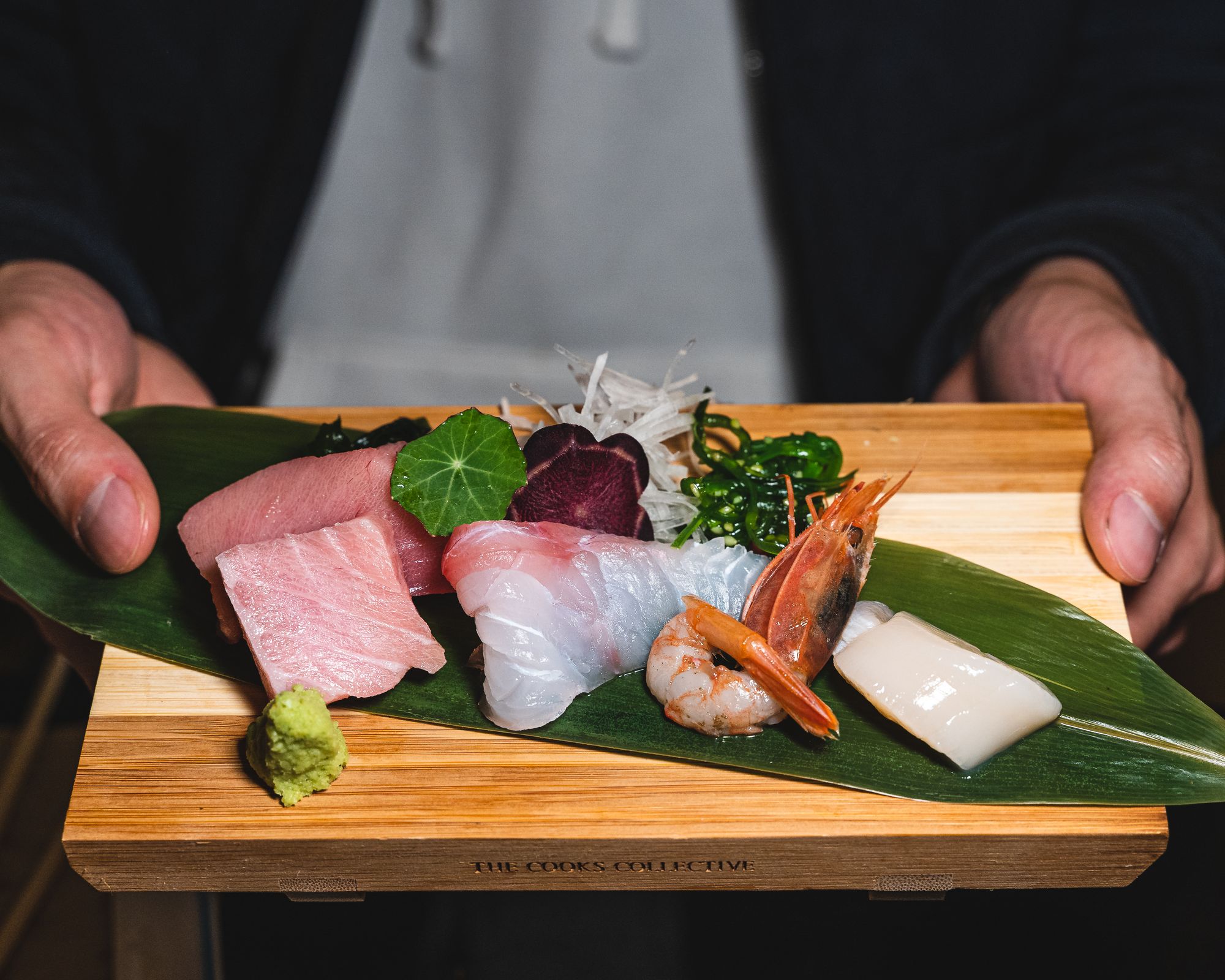 A variety of sashimi on a wooden board (toro, whitefish, ebi and hotate)