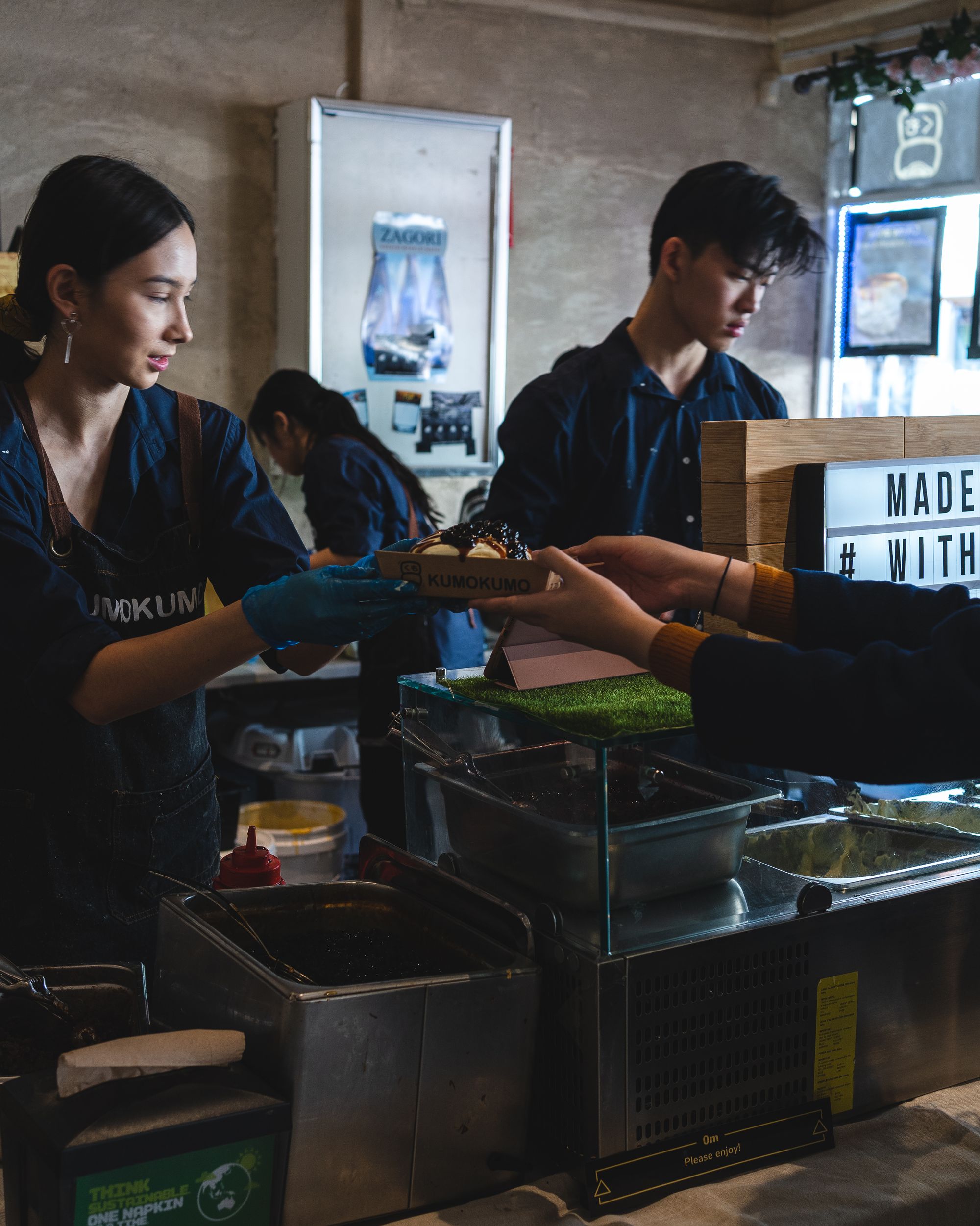 A cook handing over a serve of pancakes to a customer