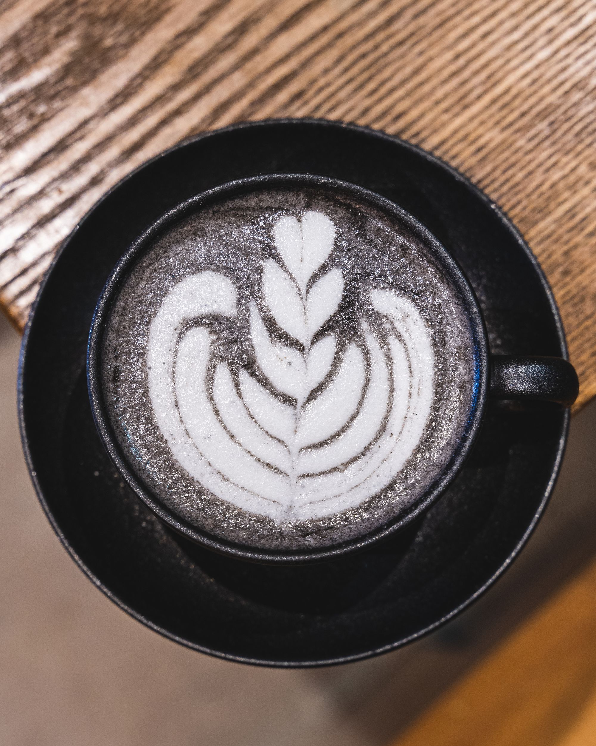 Black coloured latte in a black mug and black plate