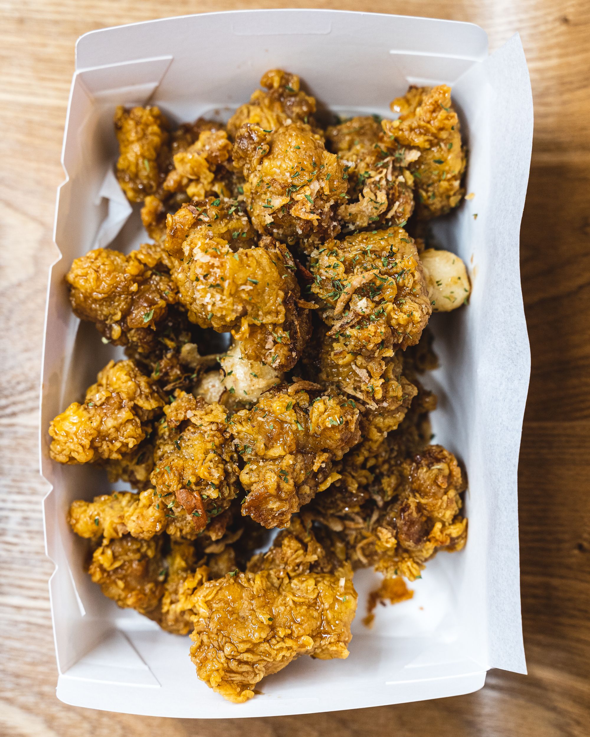 Overhead shot of Korean fried chicken in a paper box