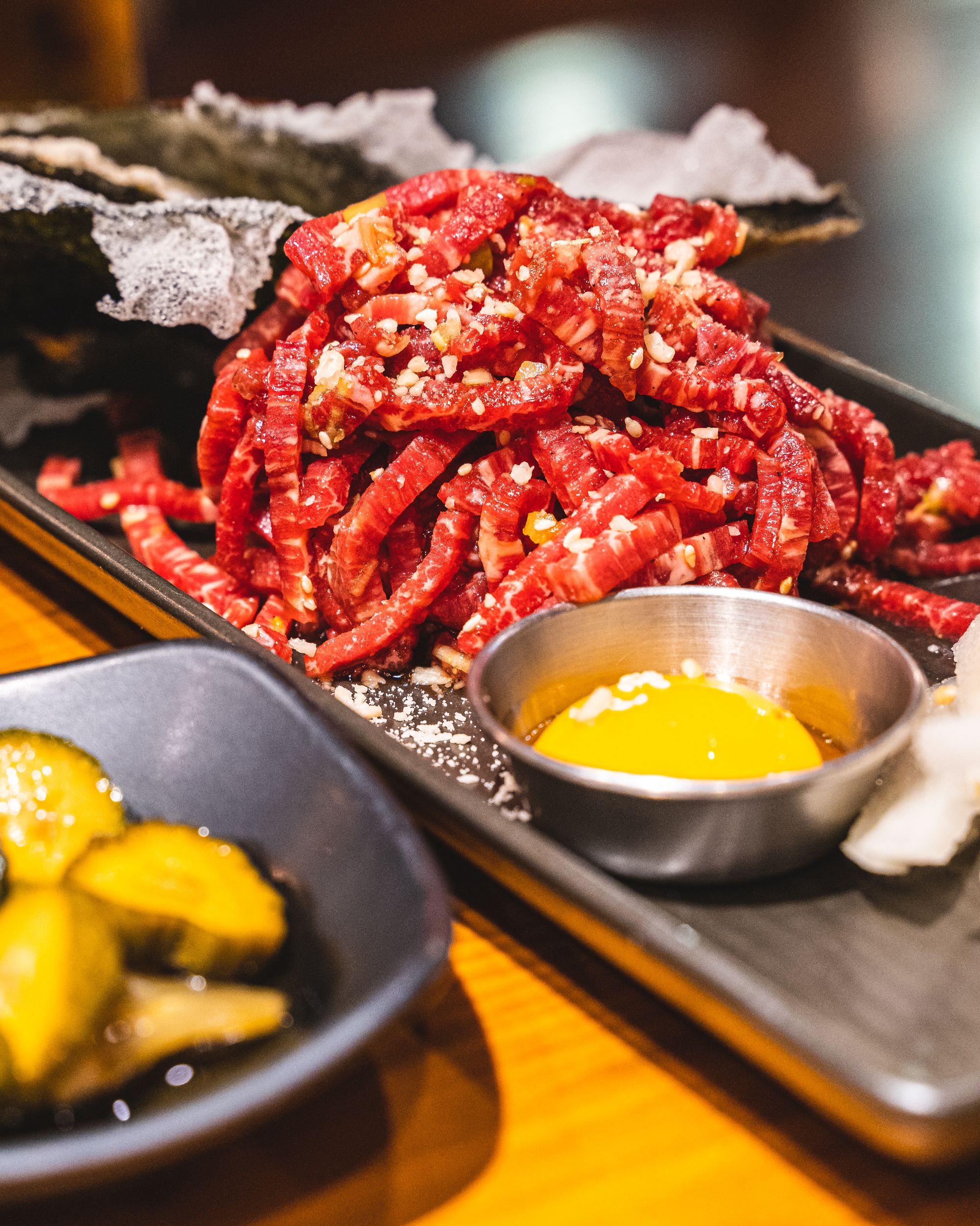 Korean beef tartare cut into strands with an egg yolk on the side