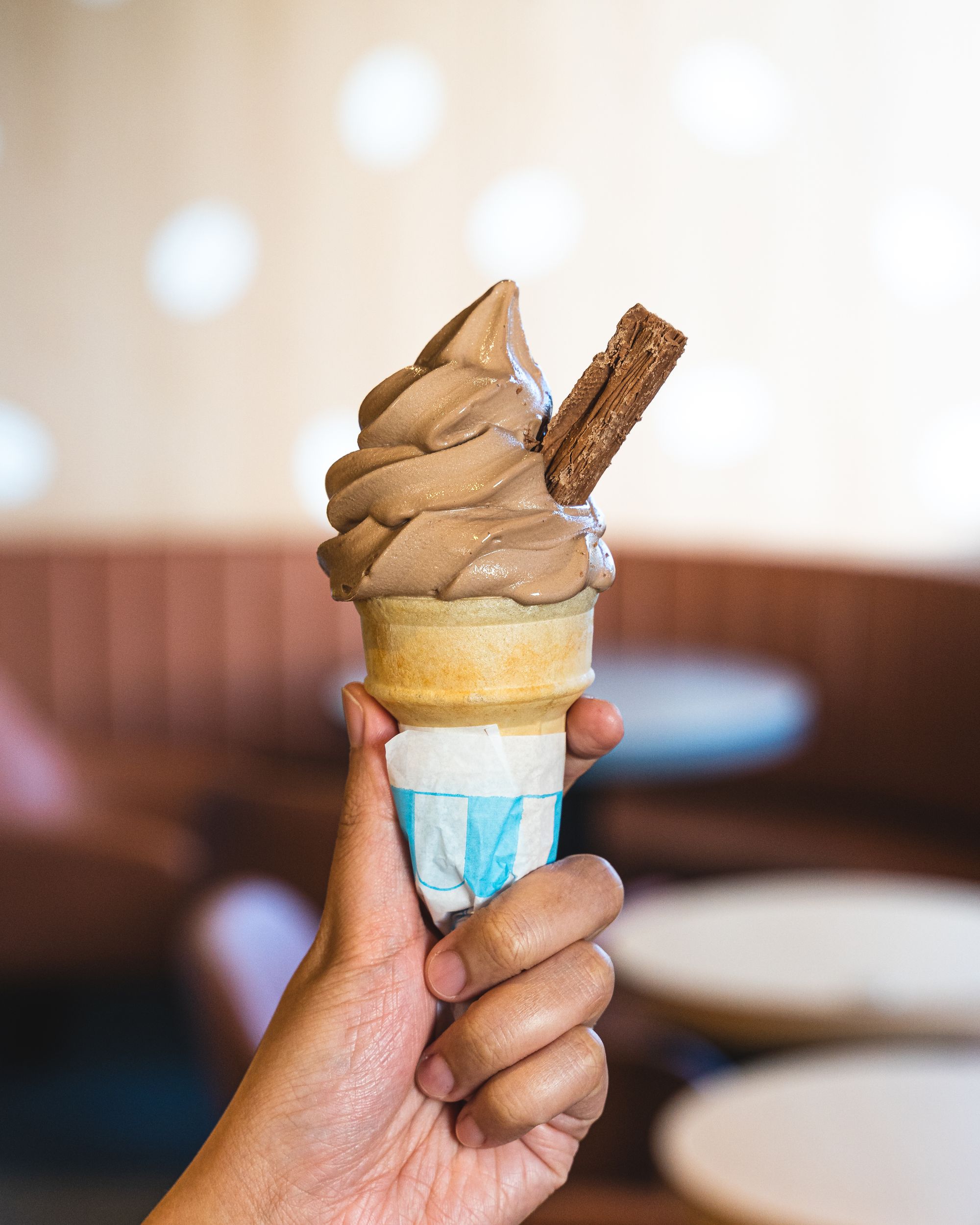 Hand holding McDonalds soft serve with flake chocolate in it
