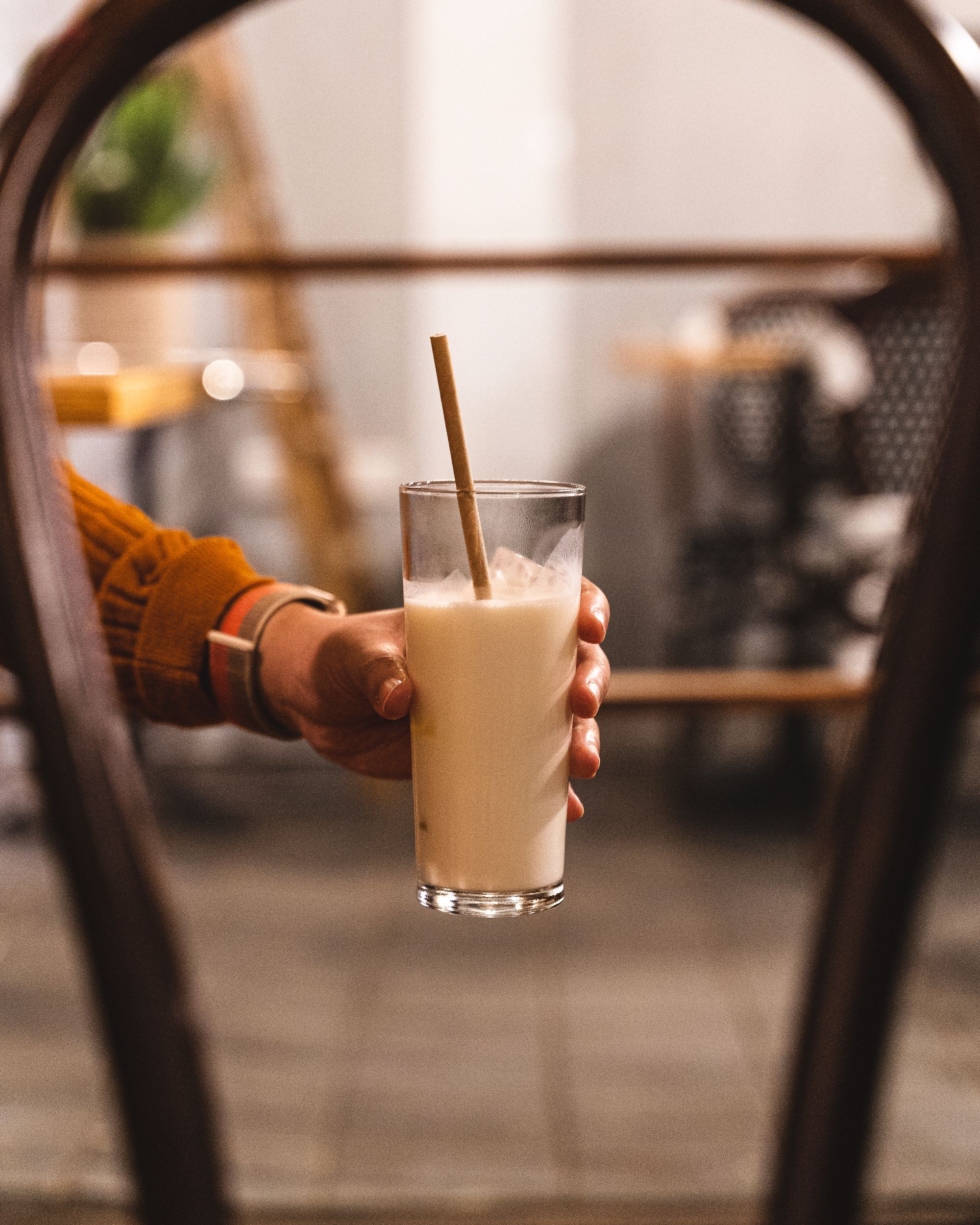 Hand holding a glass of lassi