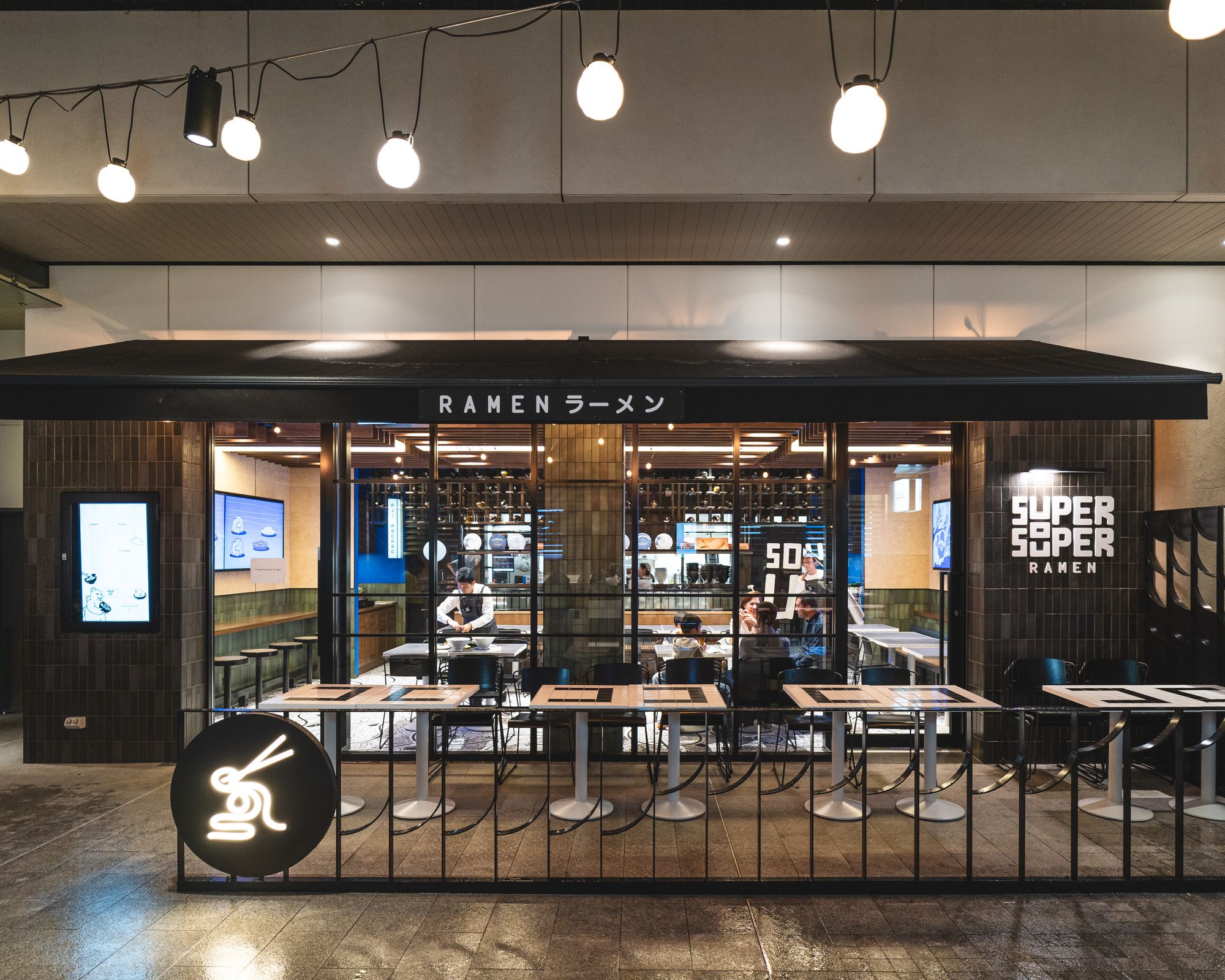 Exterior shot of Super Souper showing chairs outside and guests inside dining