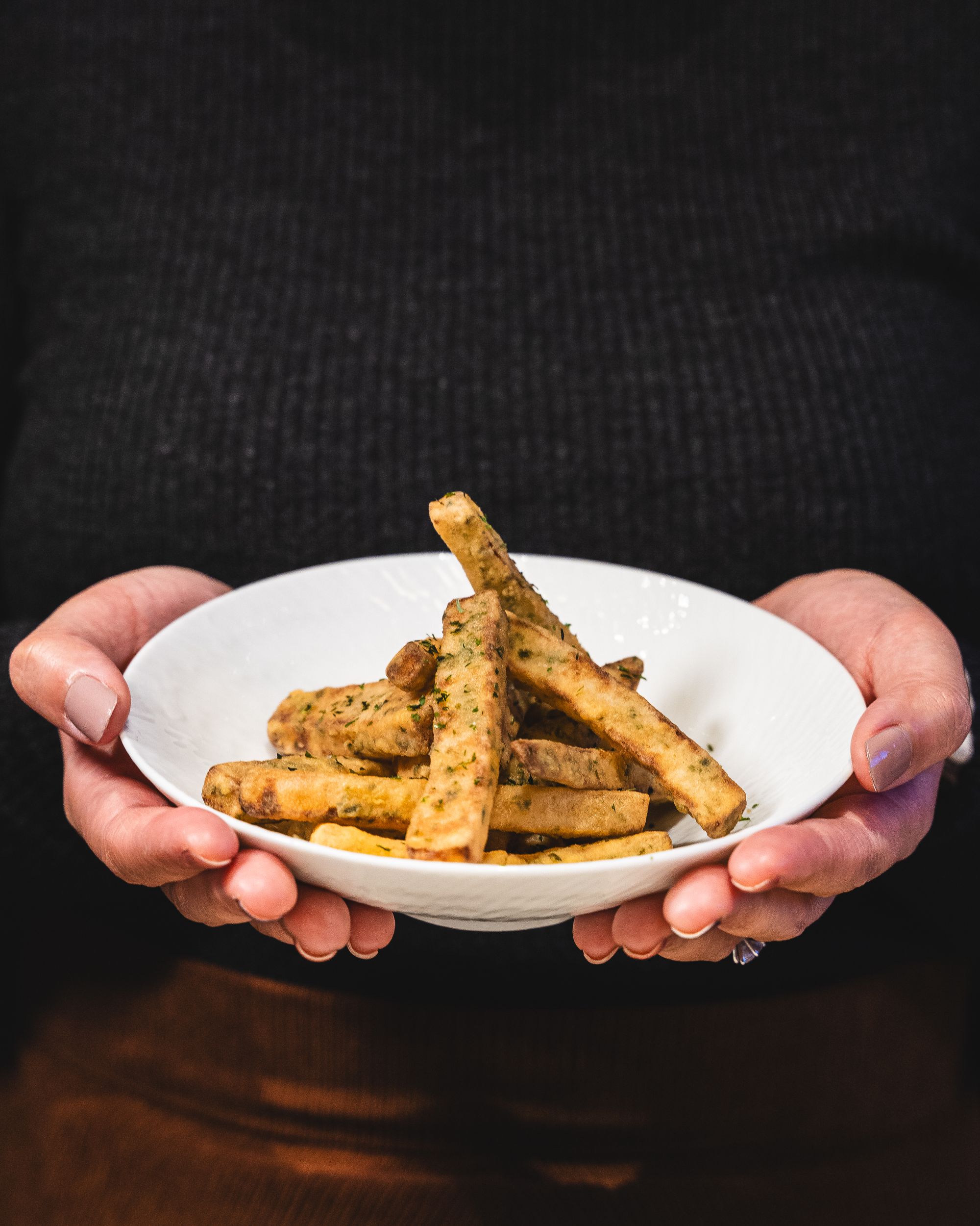 Hand holding a bowl of raddish chips