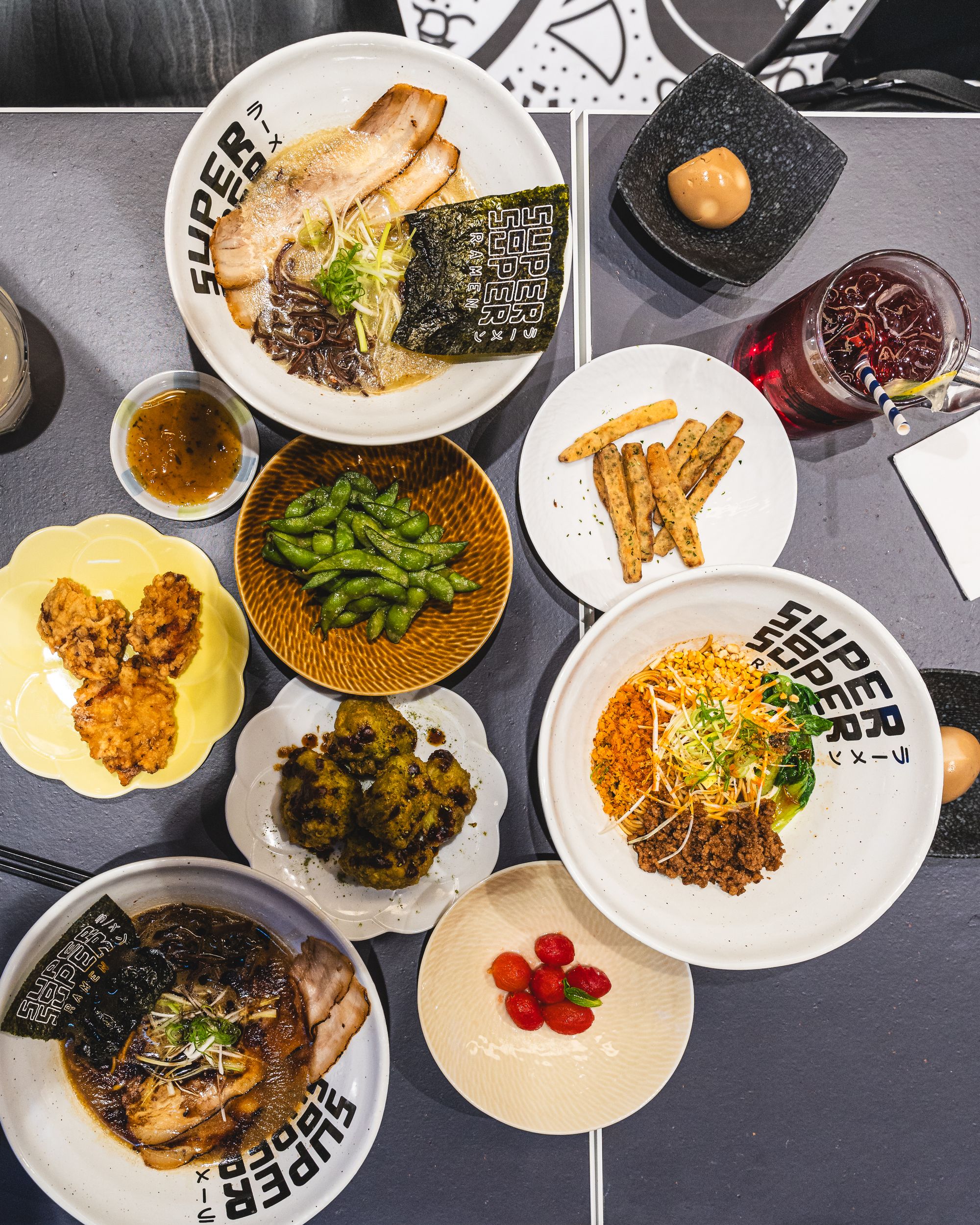Overhead shot of ramen, edamame, karaage, chips, egg and more