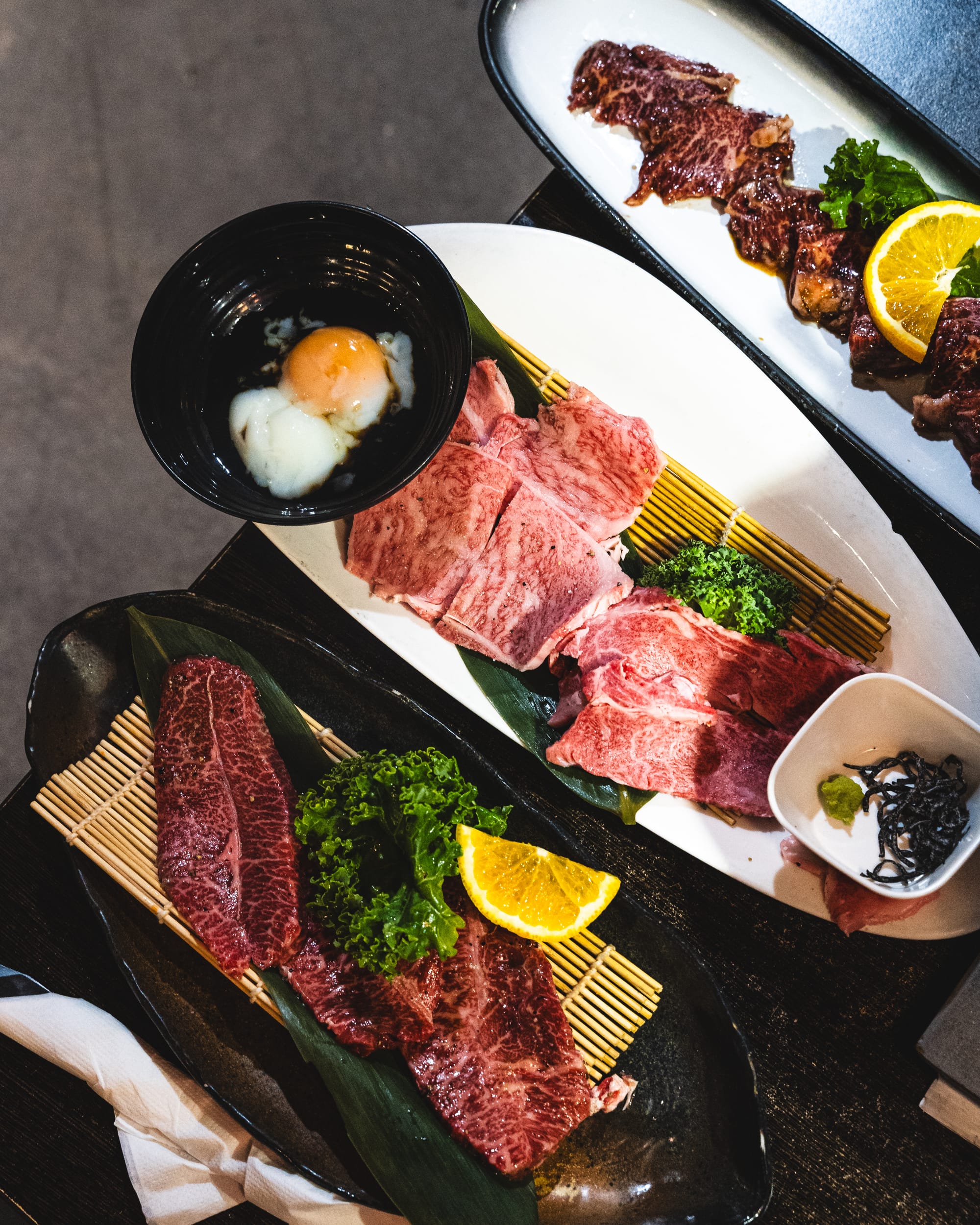 Top down shot of various plates of marbled, slice wagyu