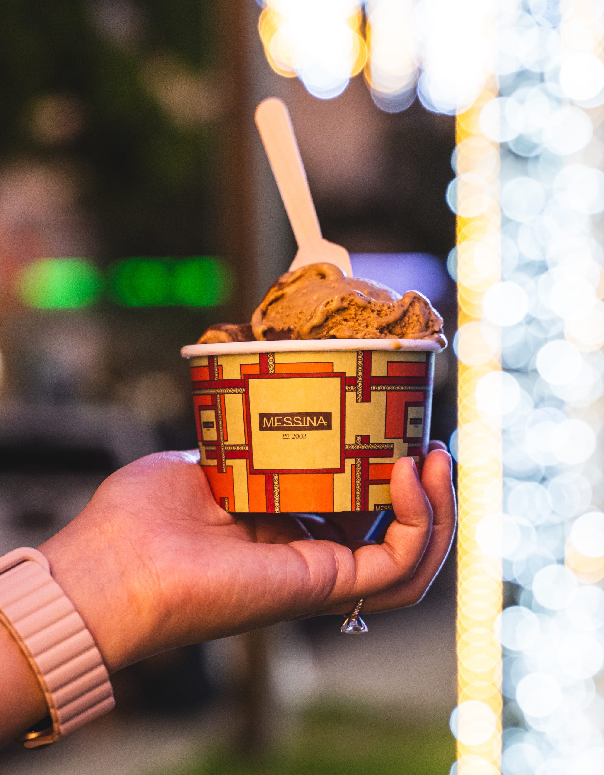 Hand holding gelato in a paper cup 