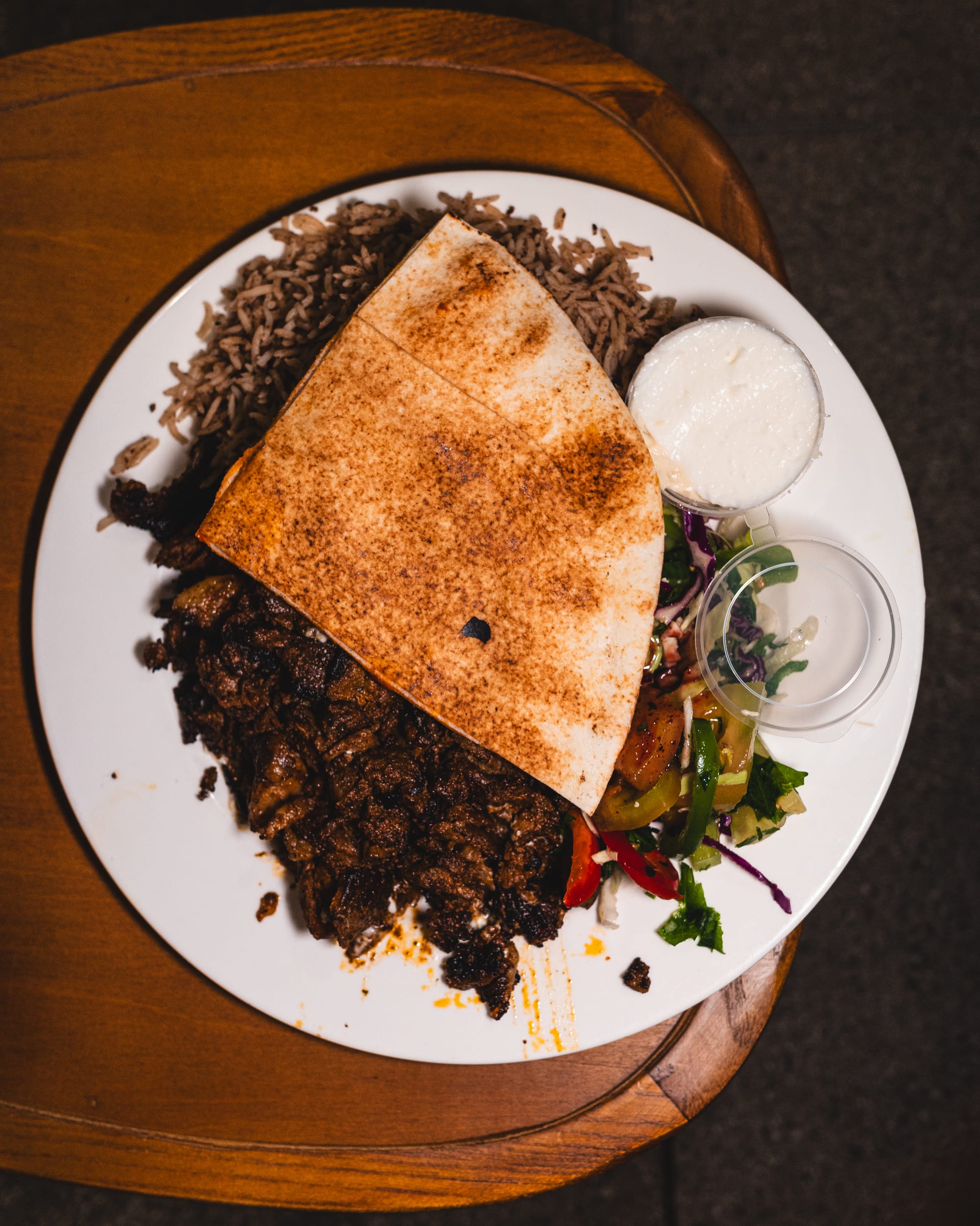 Top down shot of mince lamb with hommus, garlic dip, Lebanese bread, salad and biriyani rice