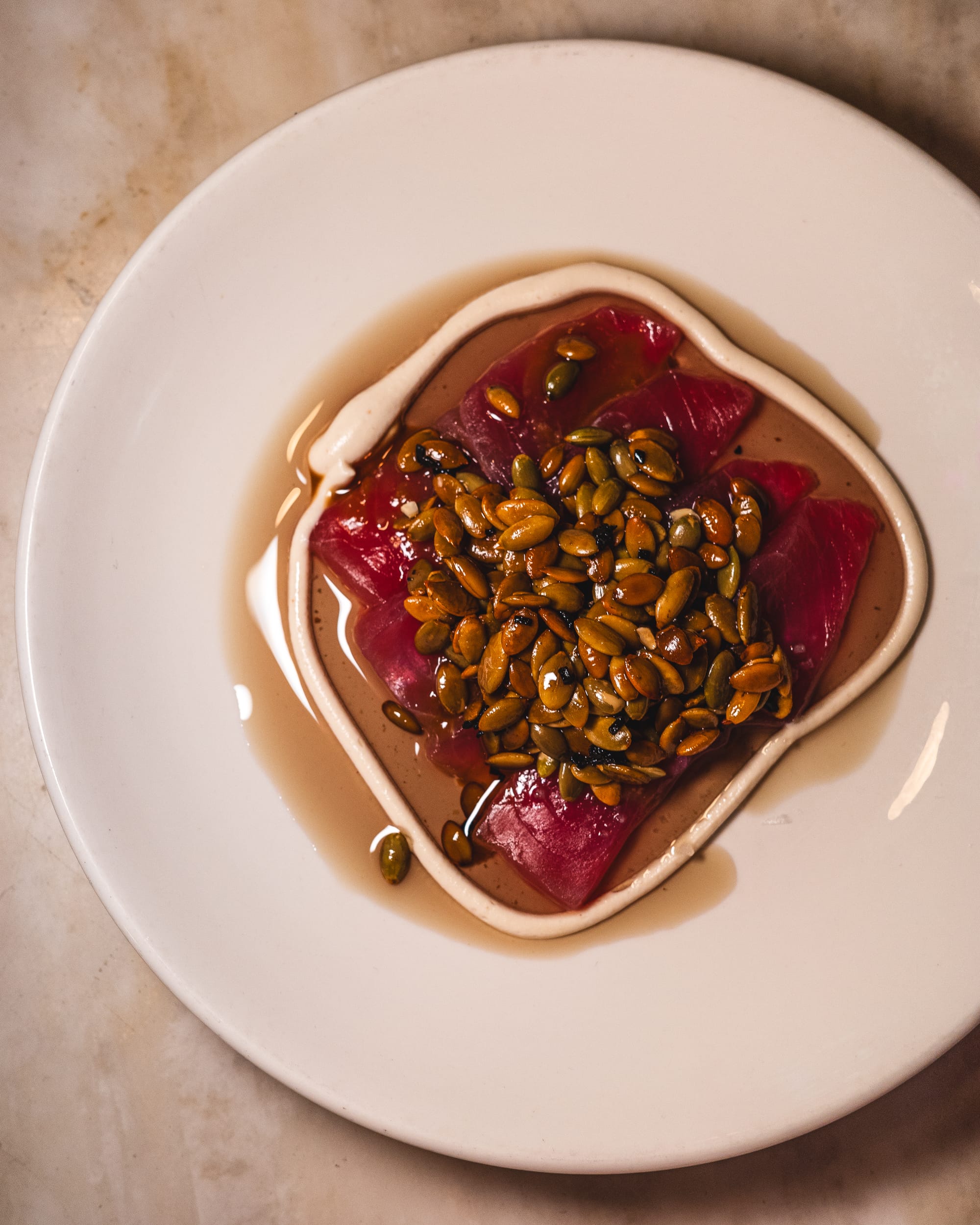 Top down shot of tuna sashimi with pumpkin seeds