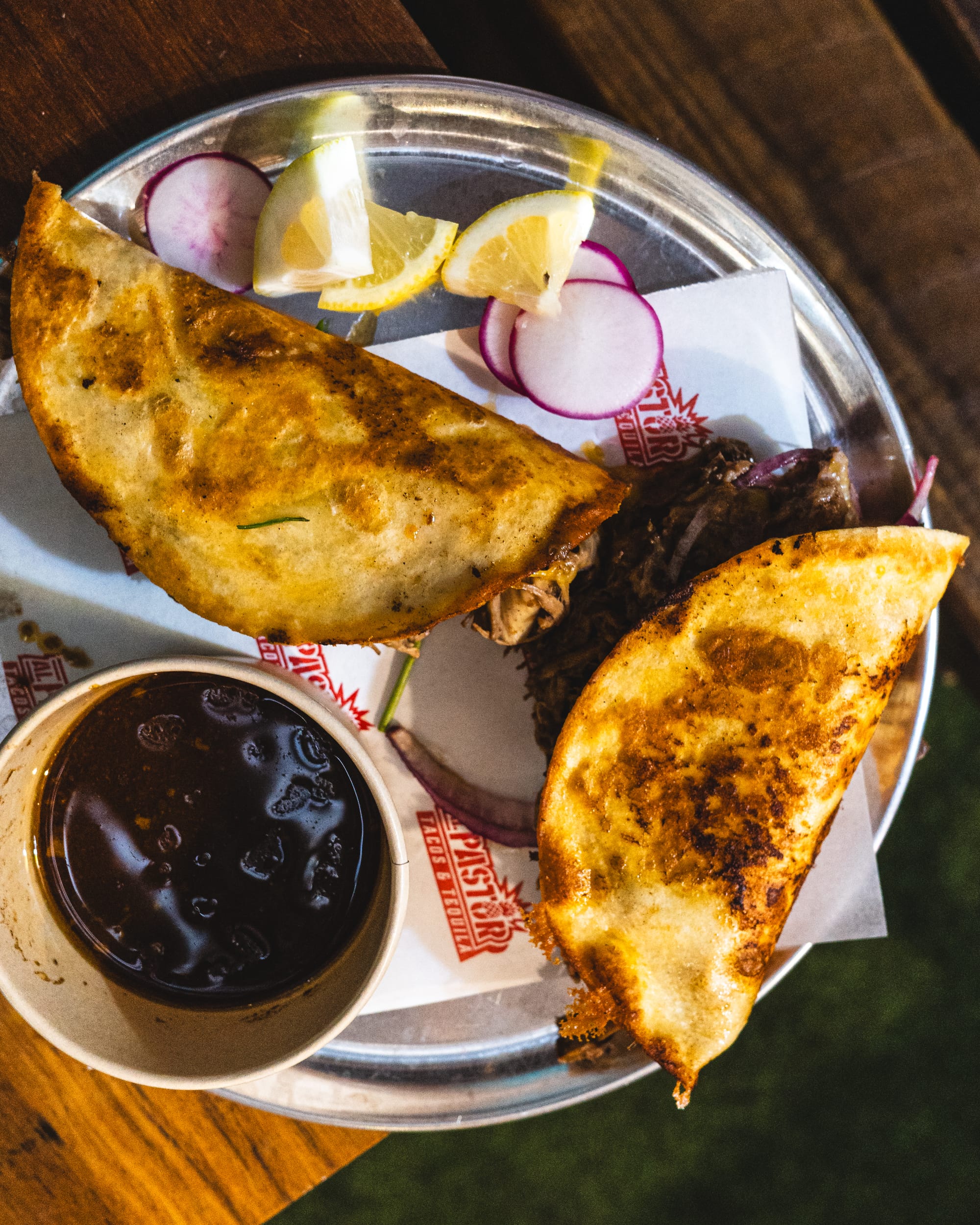 Top down shot of birria tacos with a side of consomme
