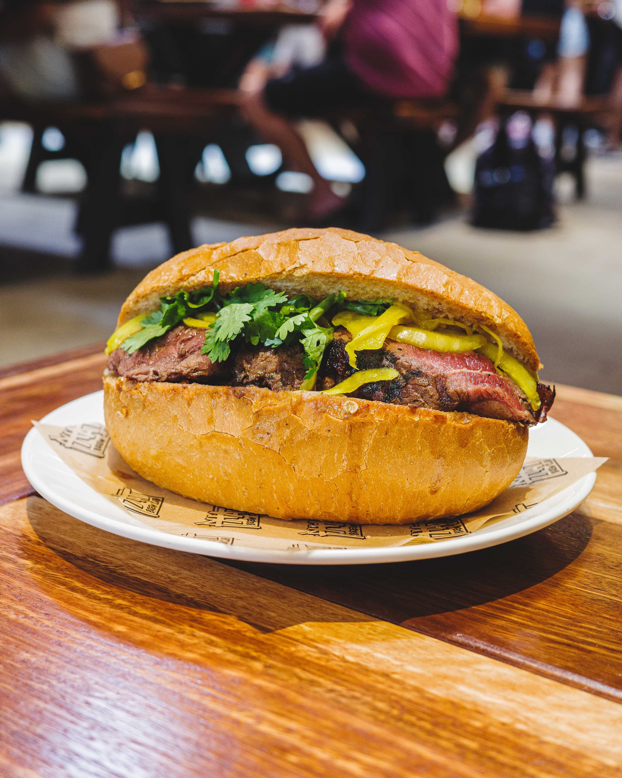Close up of steak sandwich in baguette with steak, cheese and coriander showing