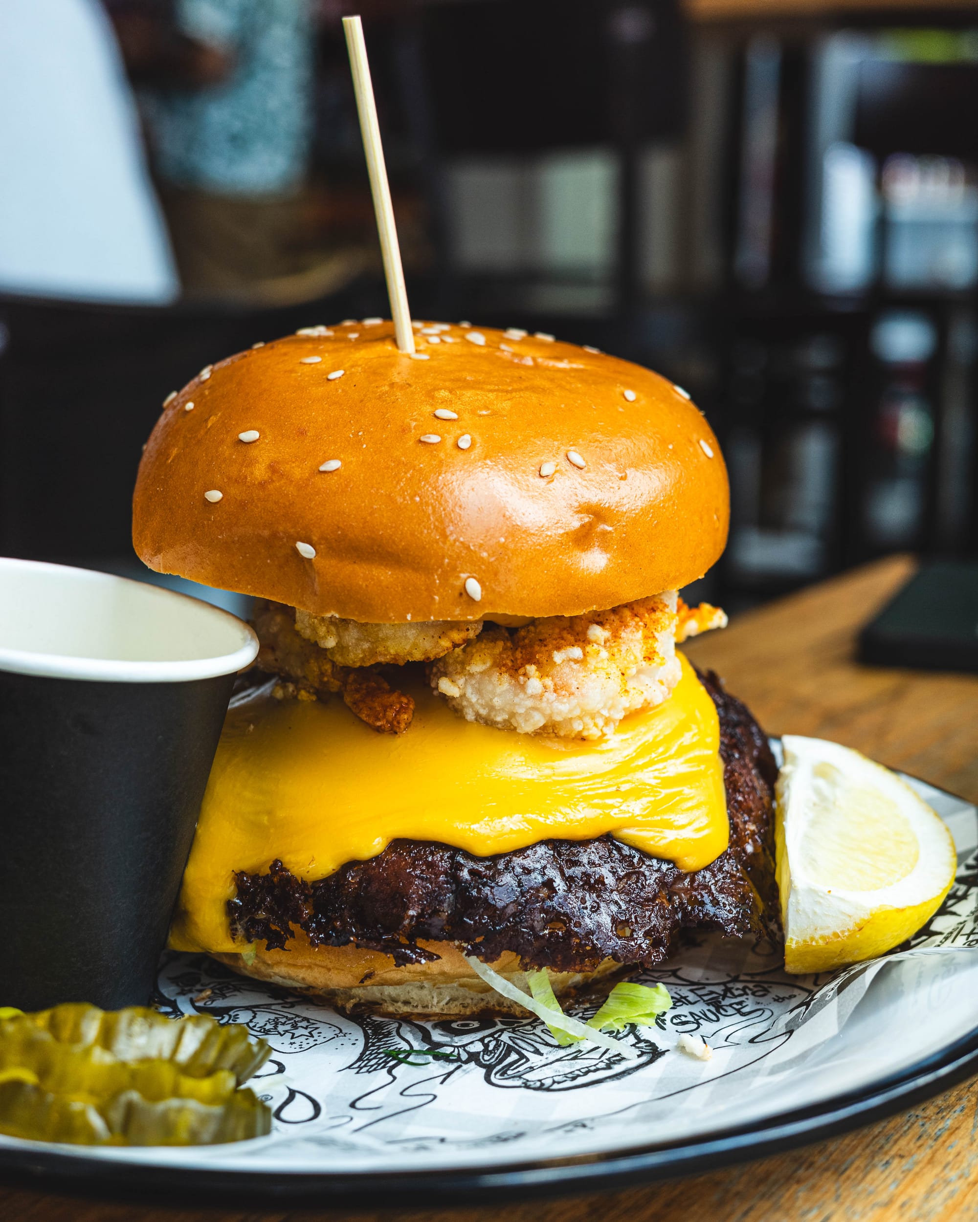Close up of burger with smashed patty, melted cheese and prawns