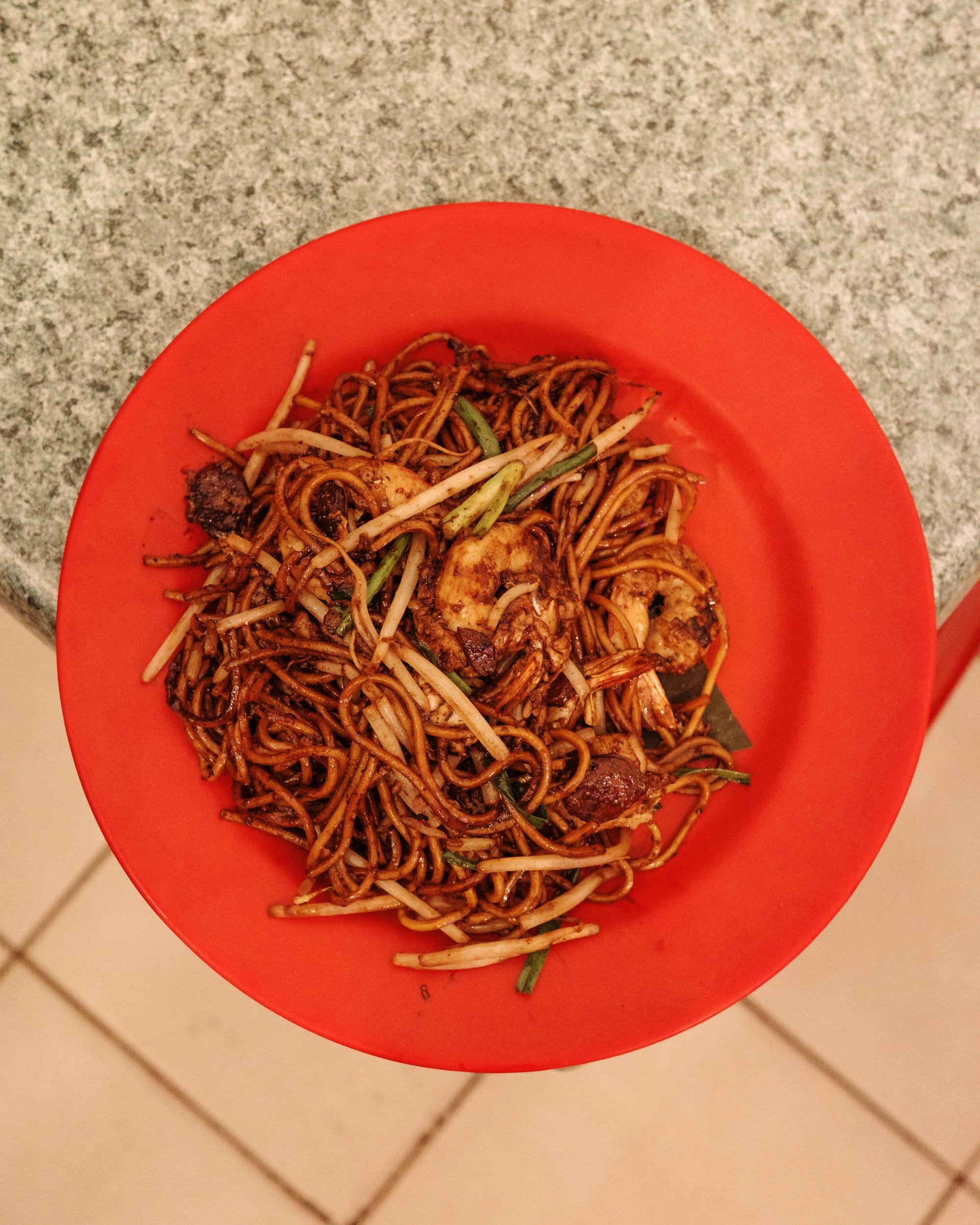 Top down shot of fried noodles with beansprouts and prawns showing