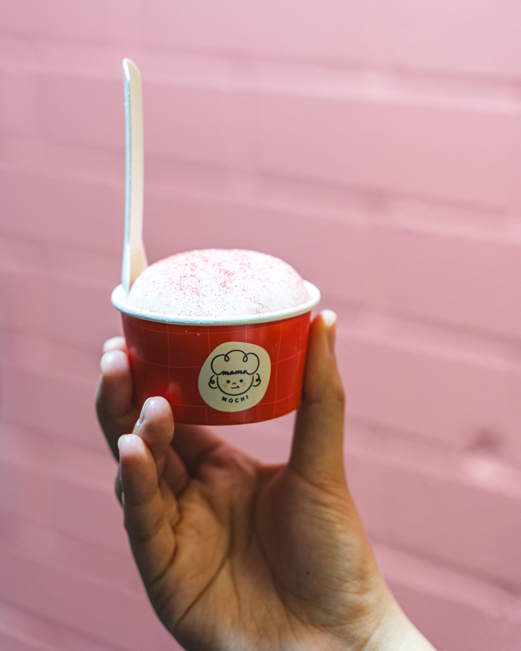 Hand holding ice cream mochi in a cup